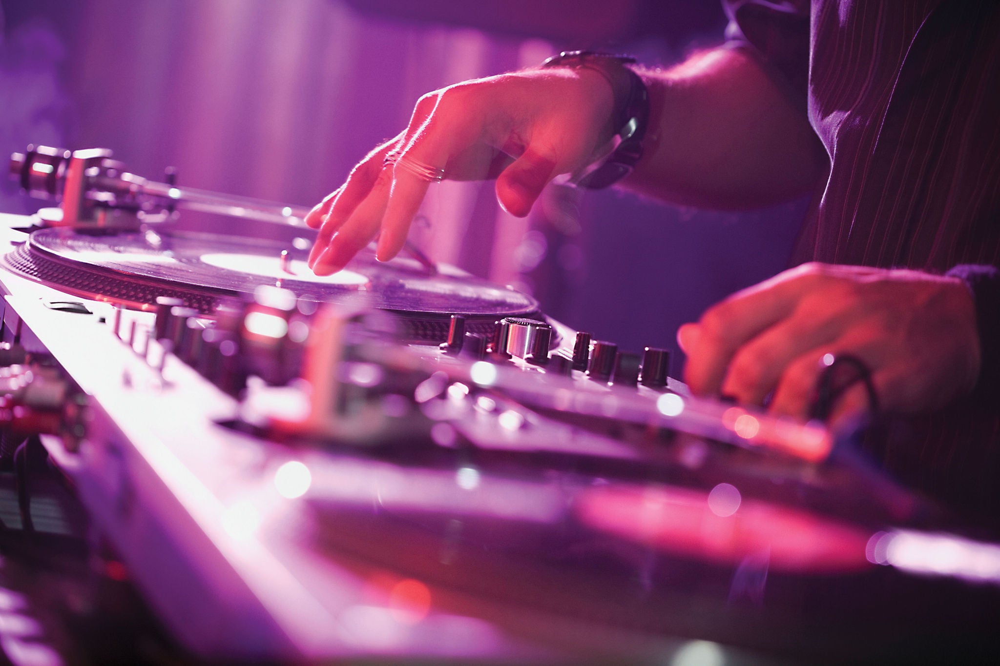 Close up of a dj on the deck in a night club