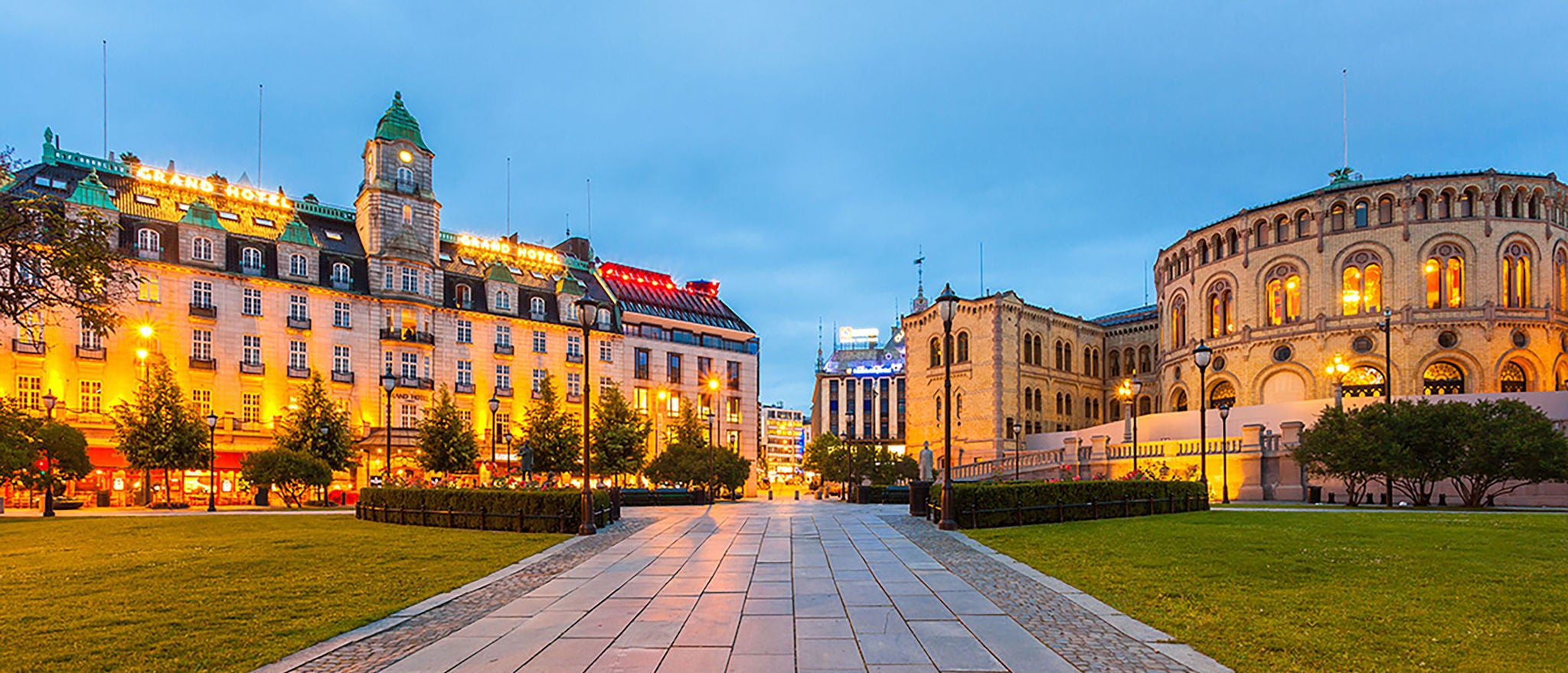 Bilde av Stortinget i Oslo med Grand Hotel og Karl Johan i bakgrunn.