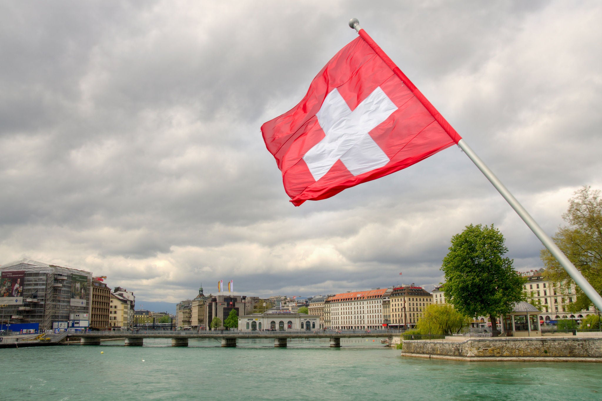 Swiss flag over the Rhone river in Geneva.