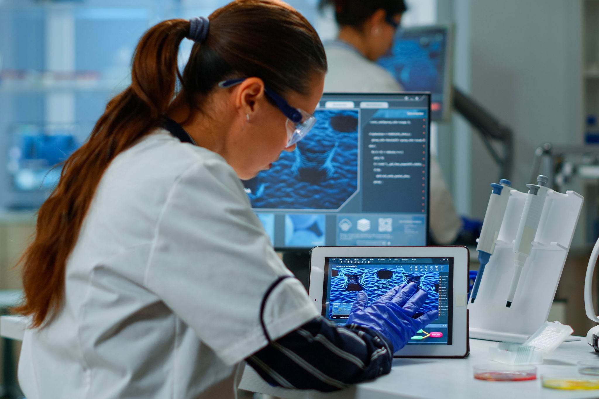 Scientist using digital tablet working in modern medical research laboratory.