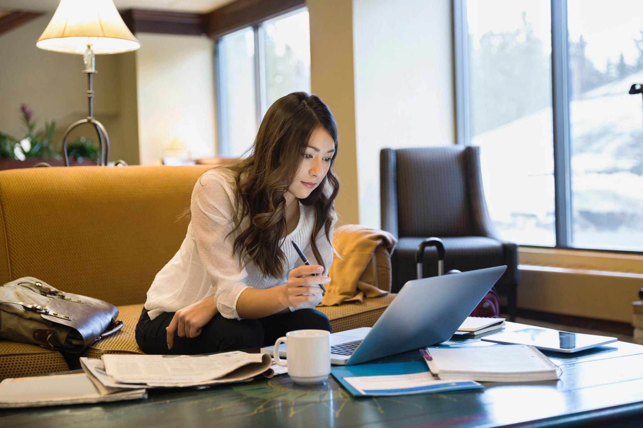 ey-businesswoman-working-laptop-hotel-lobby