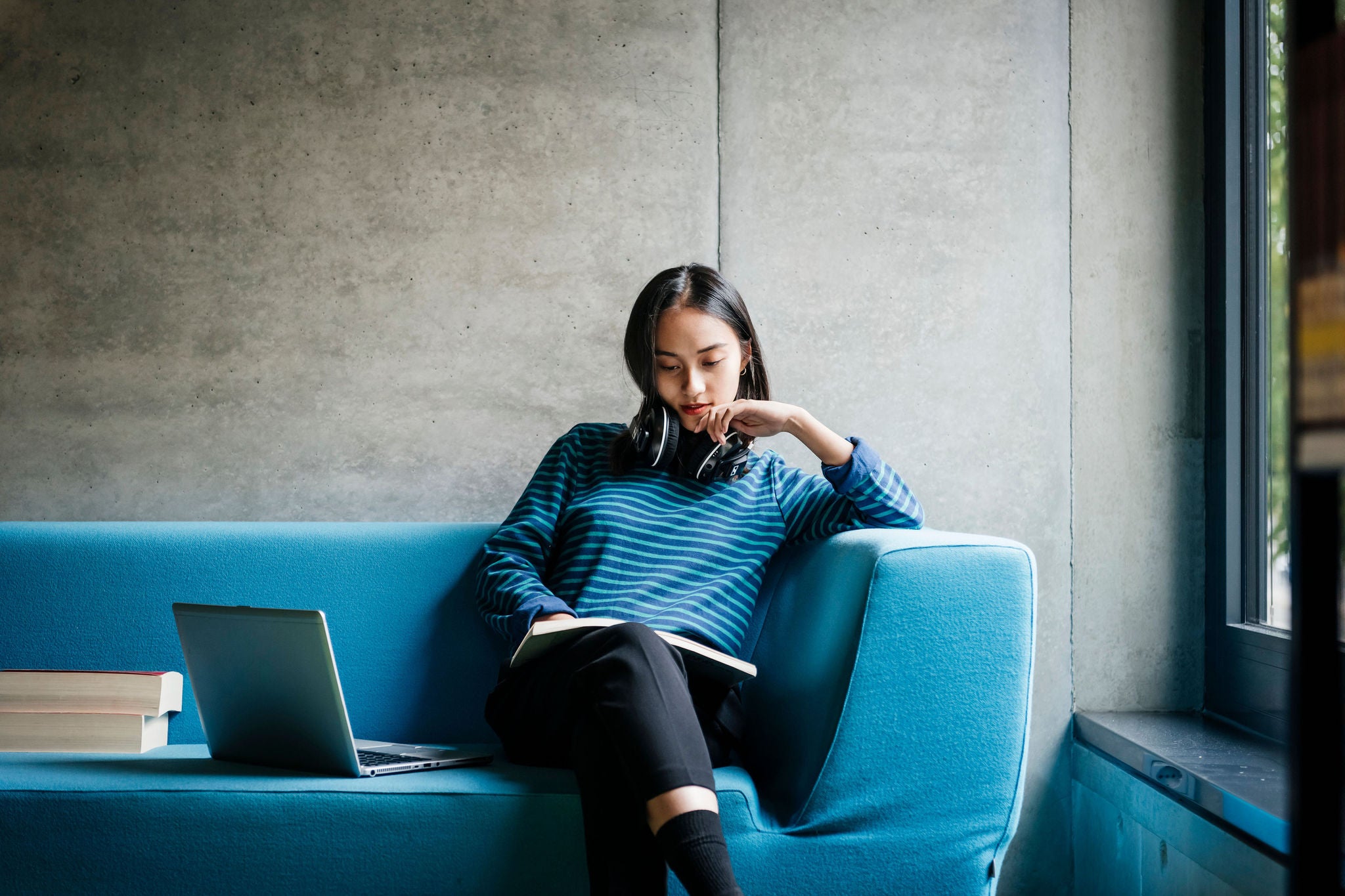 Young Woman Sitting On Couch In Library