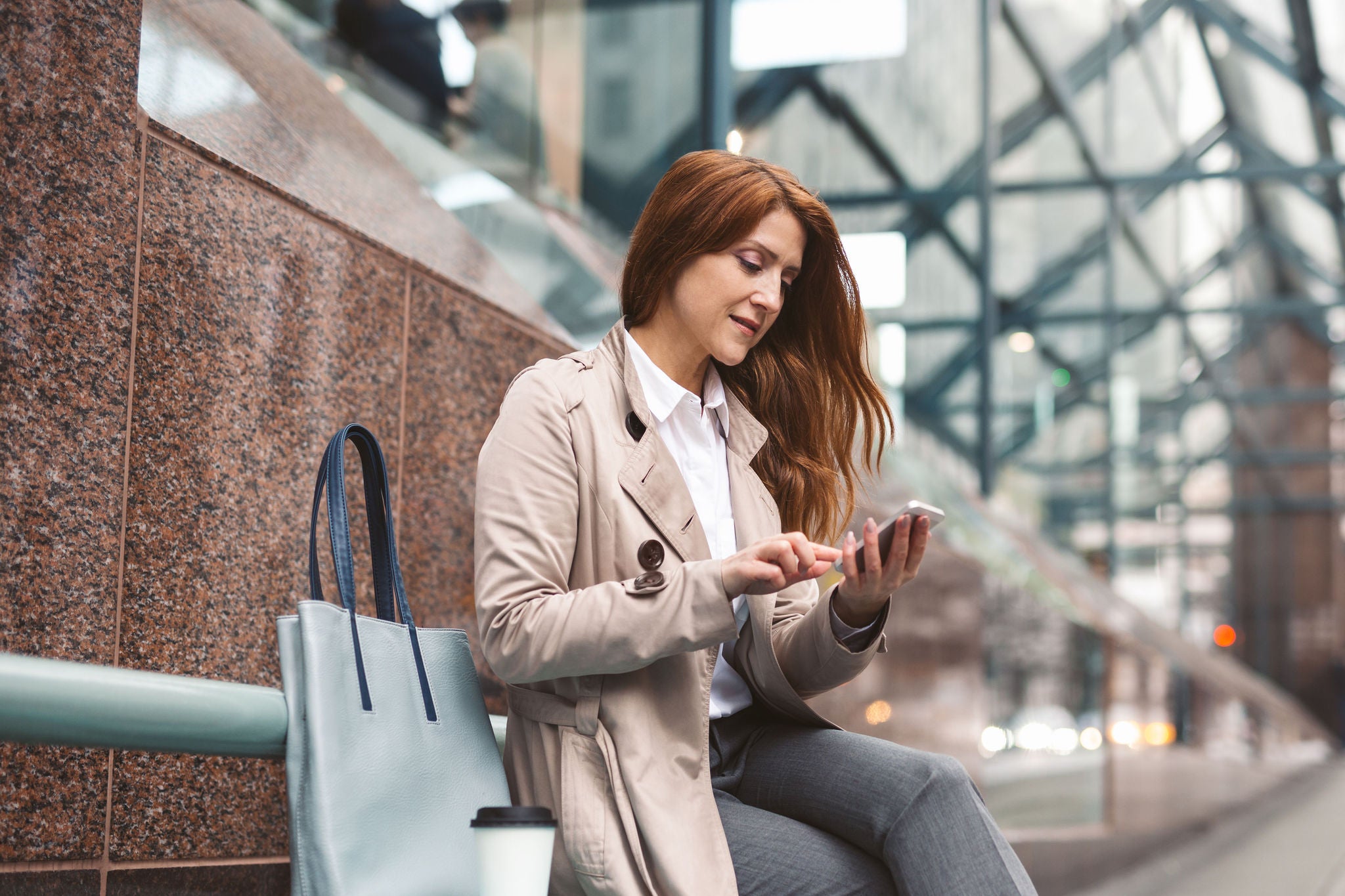 Business woman using smart phone on city street