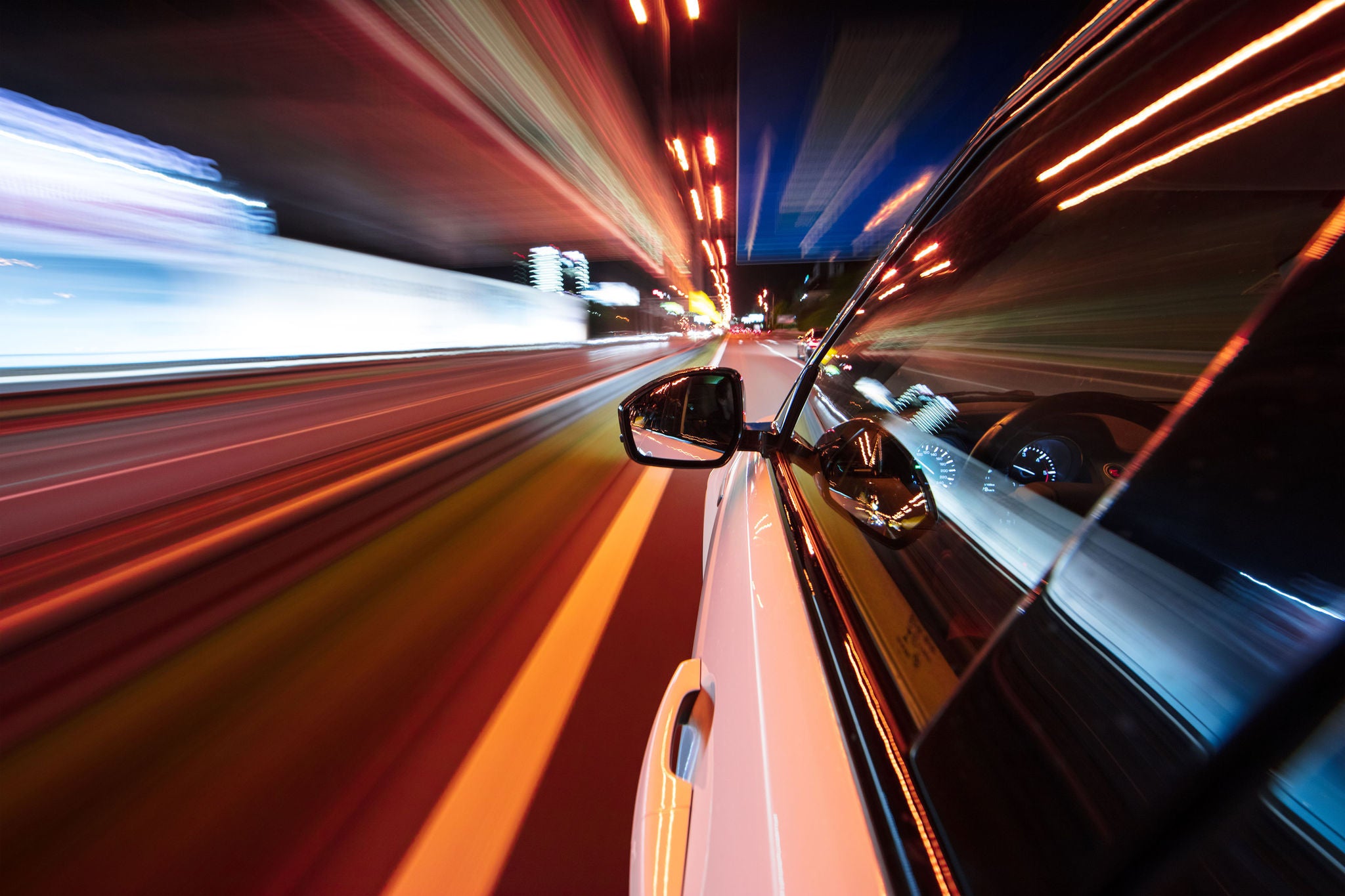 A speeding car drives through the city at night