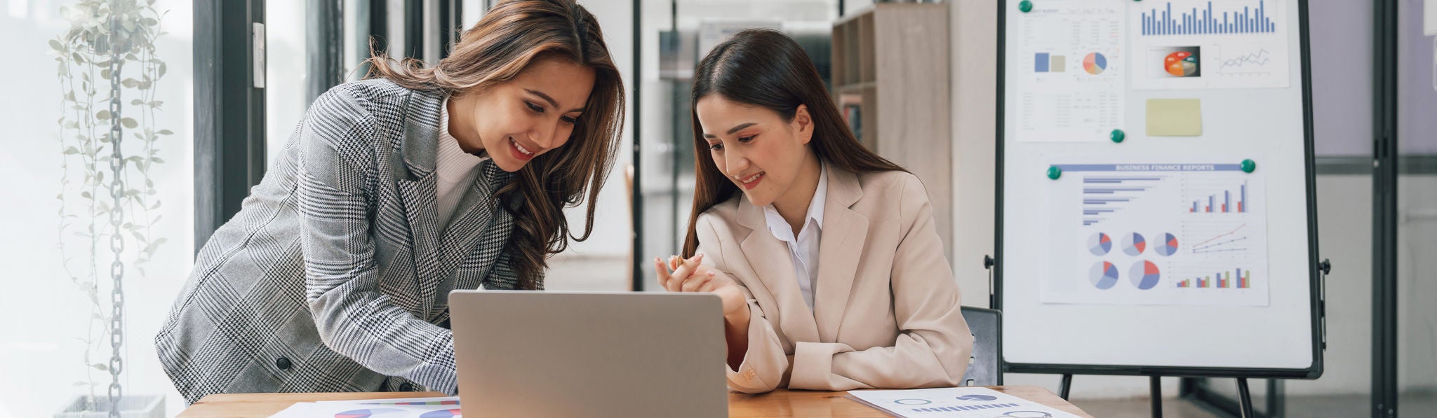 two young business woman talking together in modern office workplace