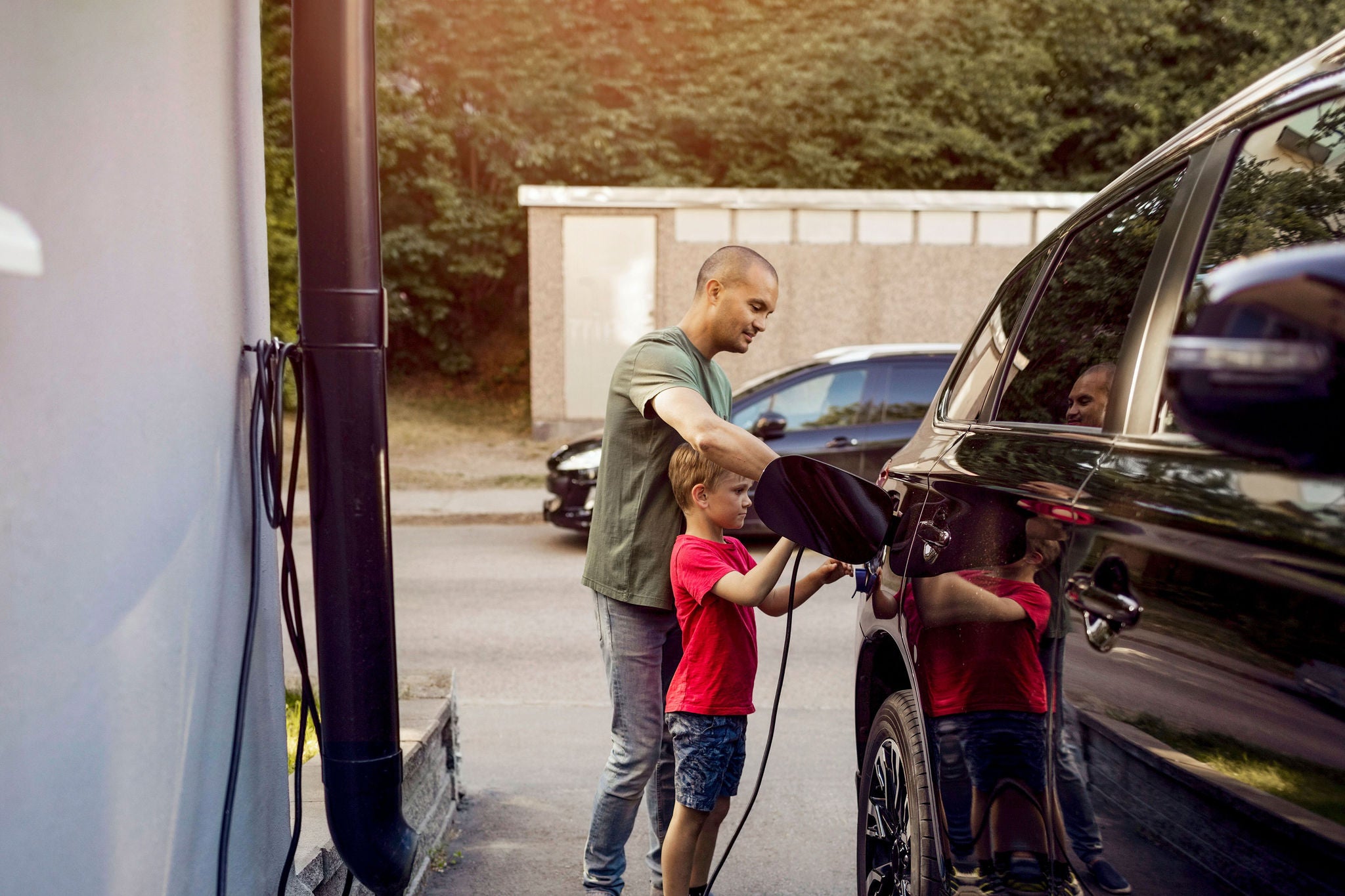 Father and son charging electric