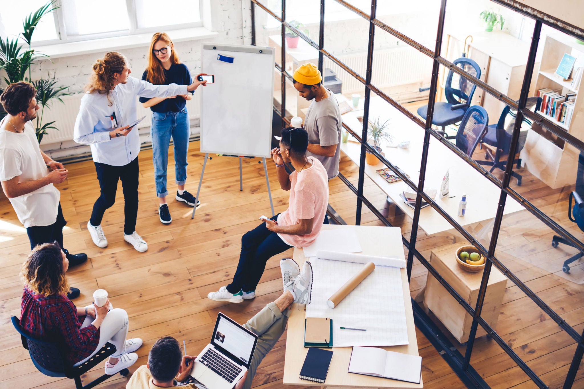 From above view of people in contemporary office having discussion and working together.