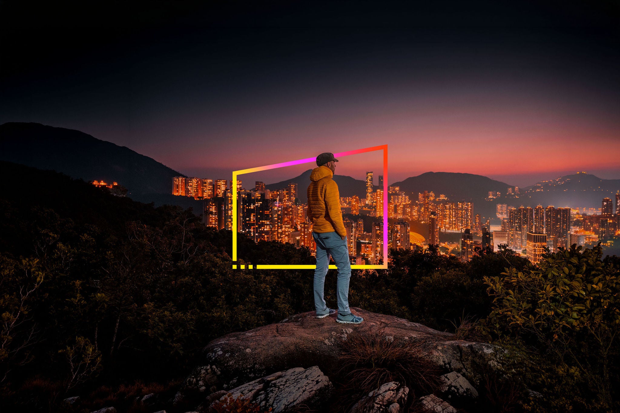 Mann betrachtet die Skyline von Hongkong bei Nacht.