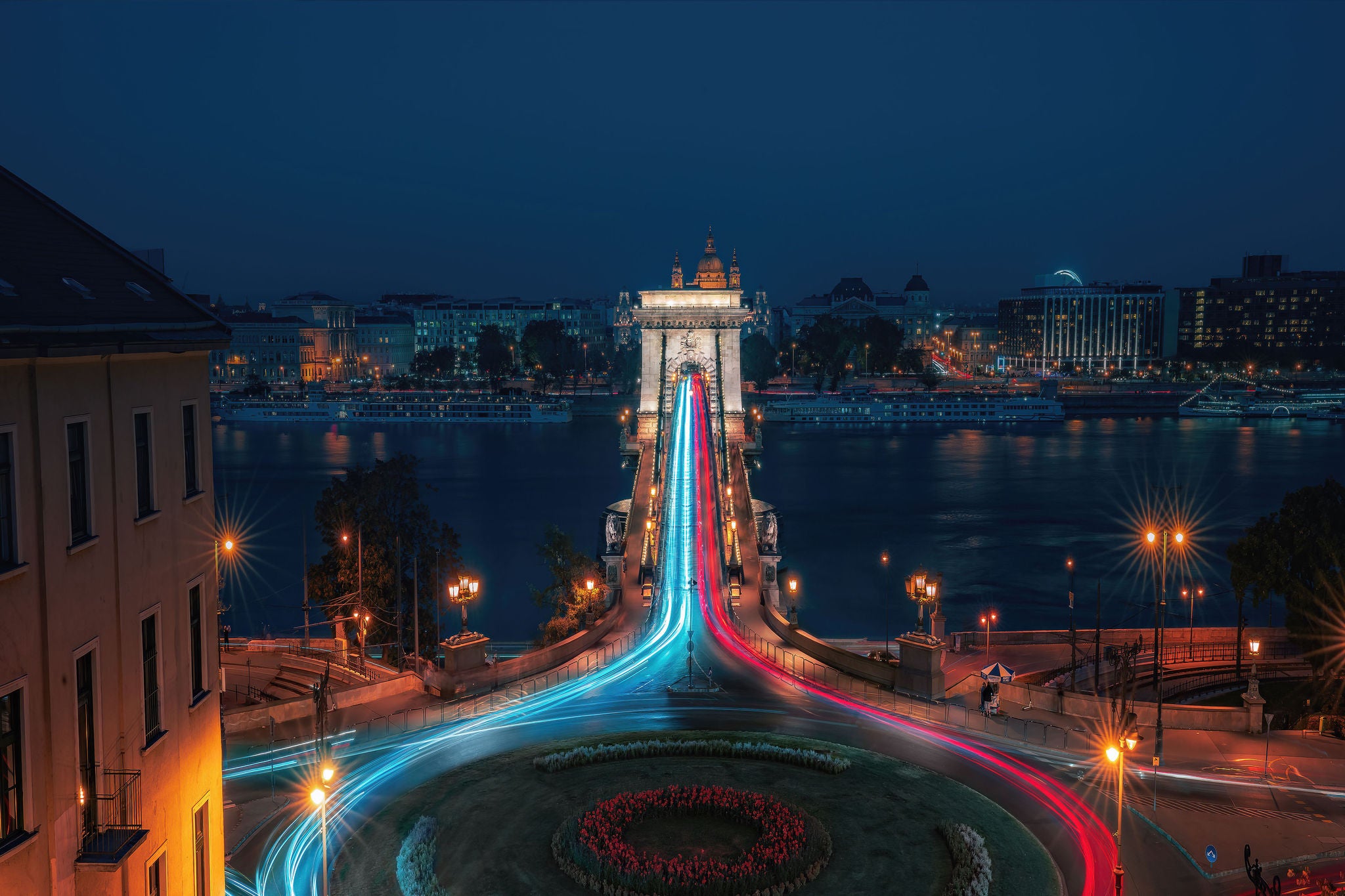Aerial view of traffic at Clark Adam Square roundabout with Szechenyi Chain Bridge and Danube river at night