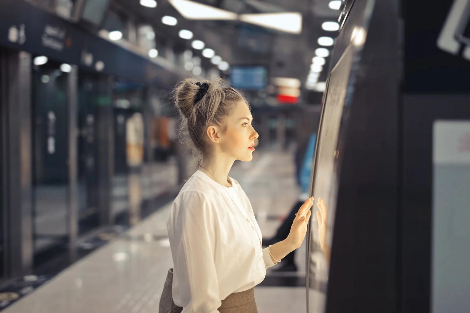 A young woman is touching the screen in an airport. Costumer service machine with ai.
