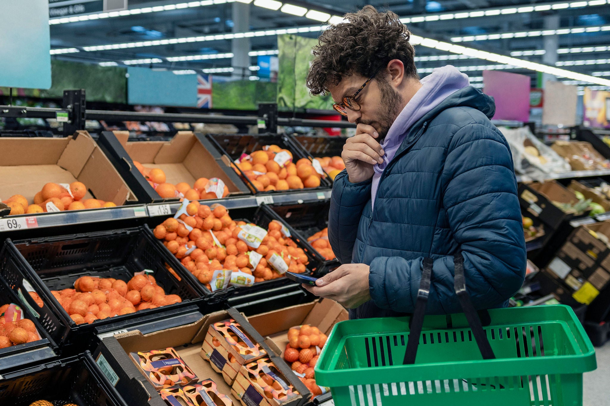 homem pensativo ao fazer compras em um mercado.