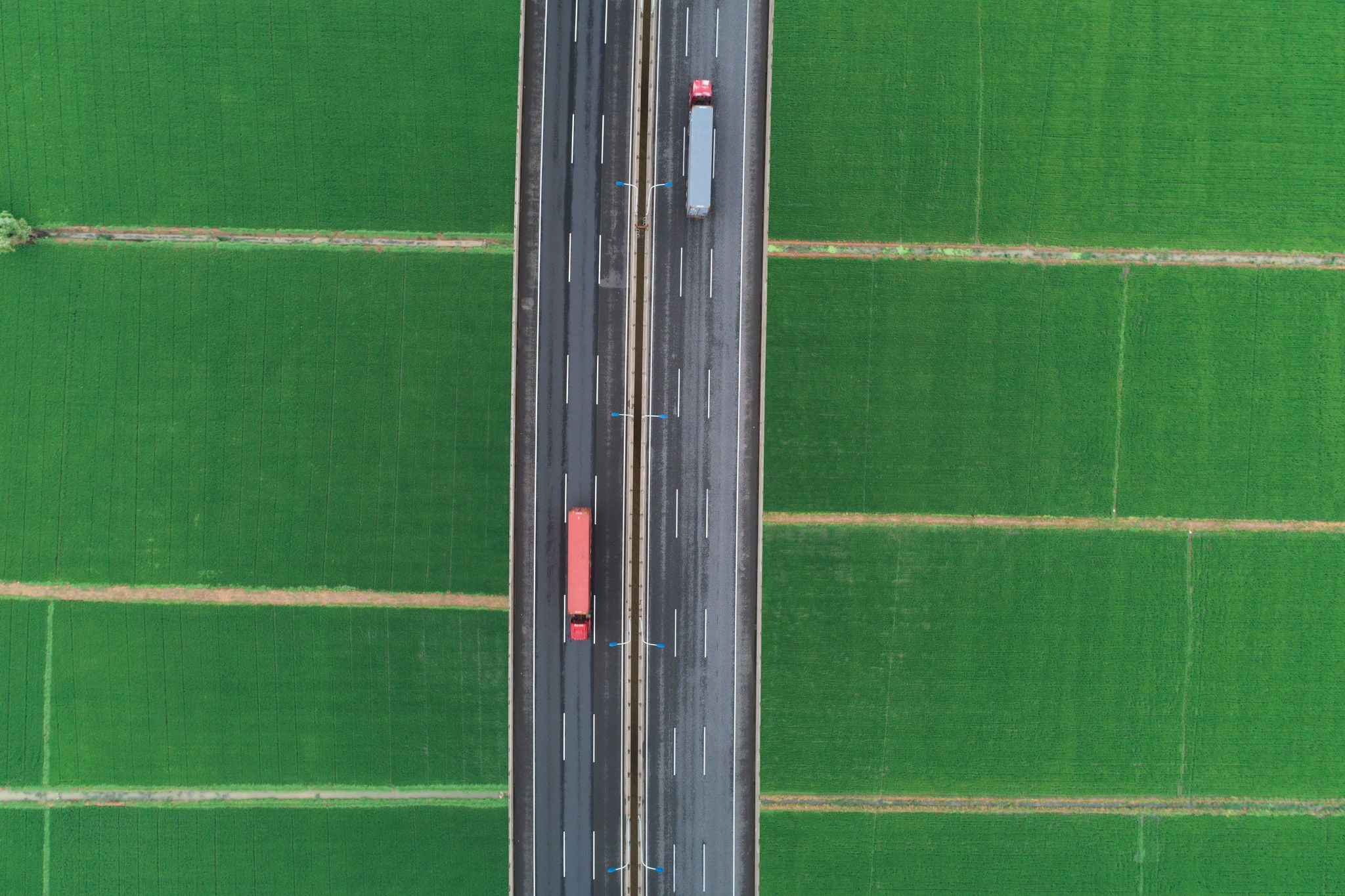 Aerial view of road between green meadow - copy space