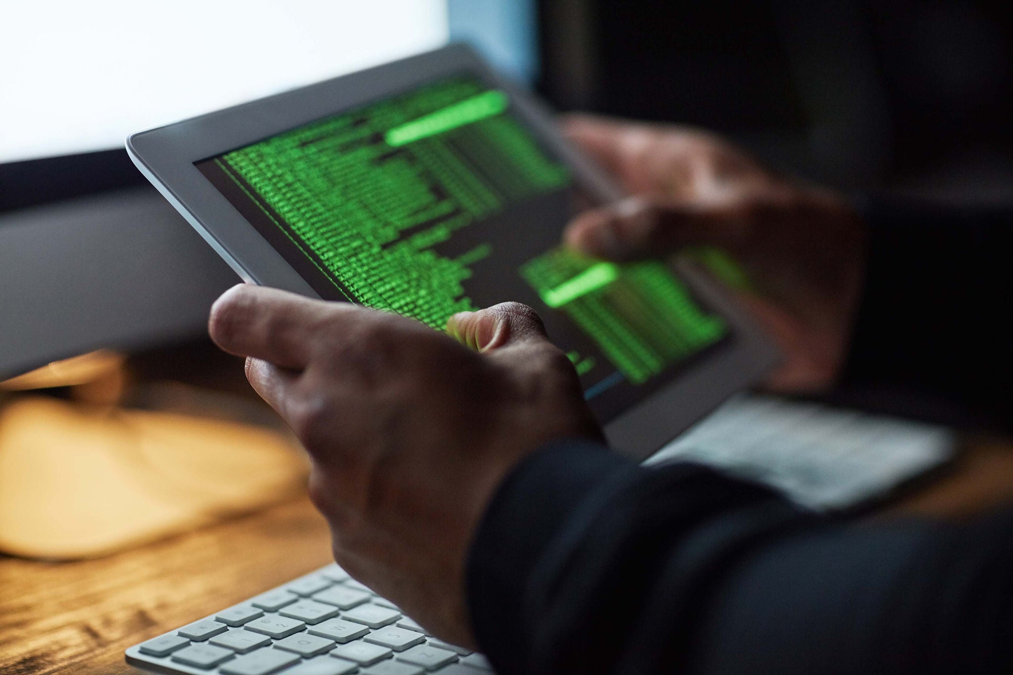 Cropped shot of an unidentifiable hacker cracking a computer code in the dark