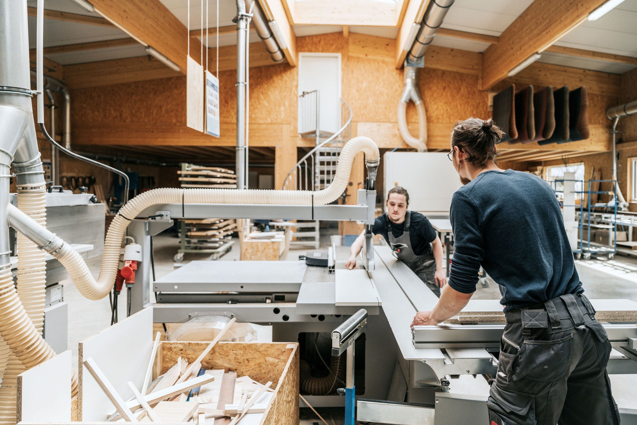 Zwei junge Schreiner arbeiten an Kreissaegemaschine in der Werkstatt