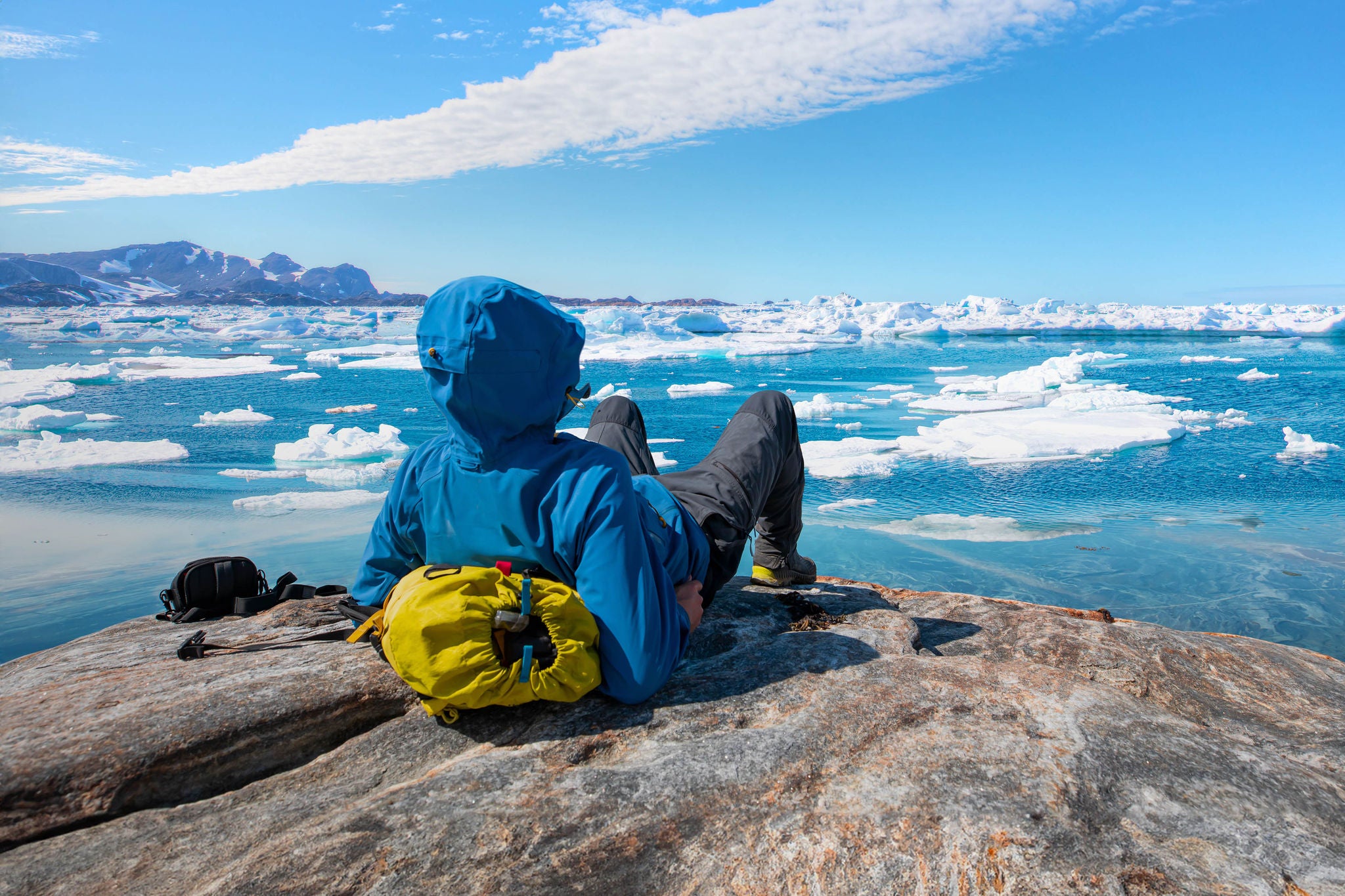 A man hiker looking at melting glacier