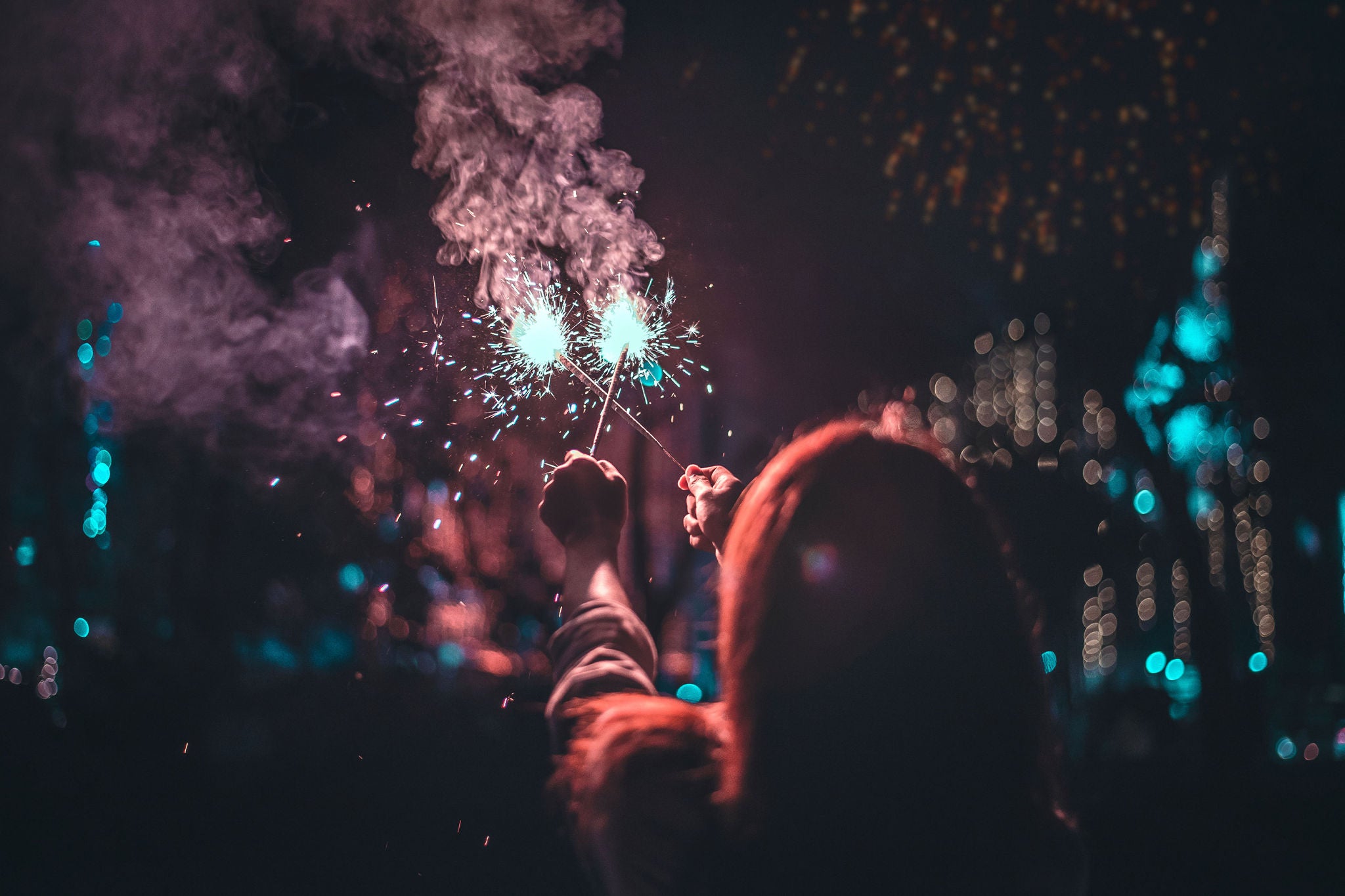 Mujer sosteniendo luces brillantes en la noche