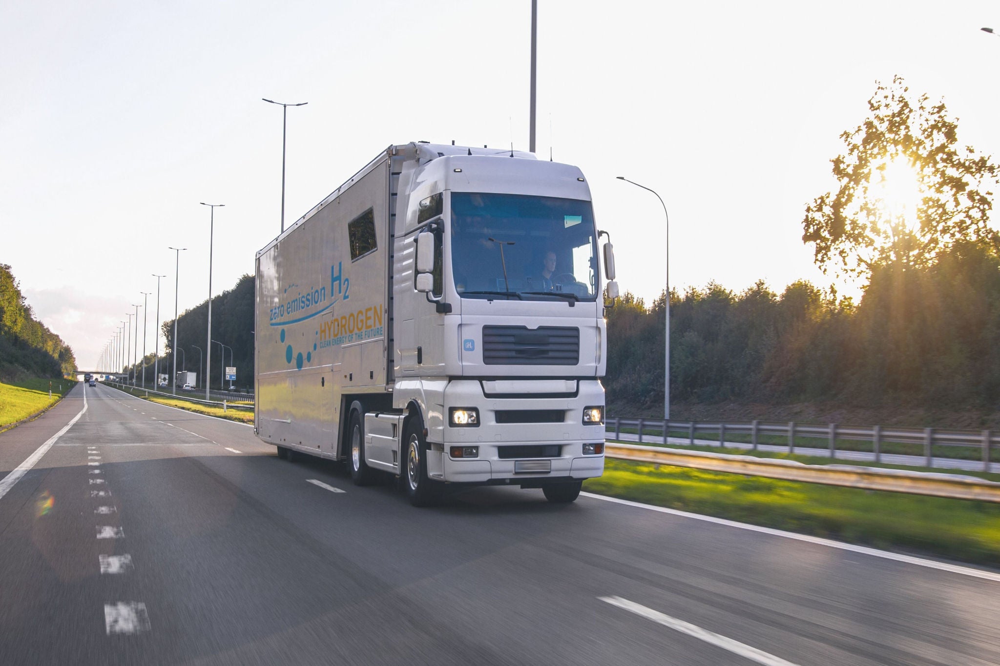 A white colored bus is going on road