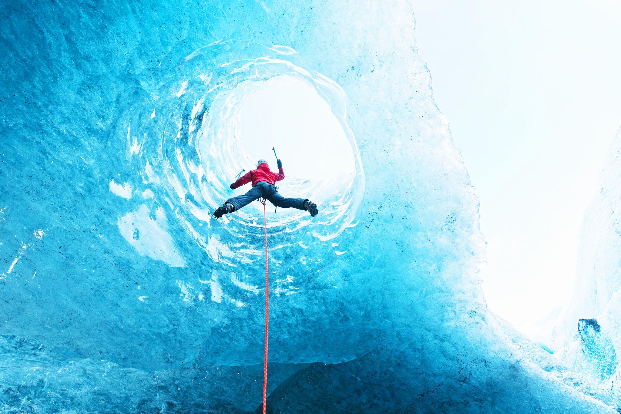 ey woman climbing out of glacier cave