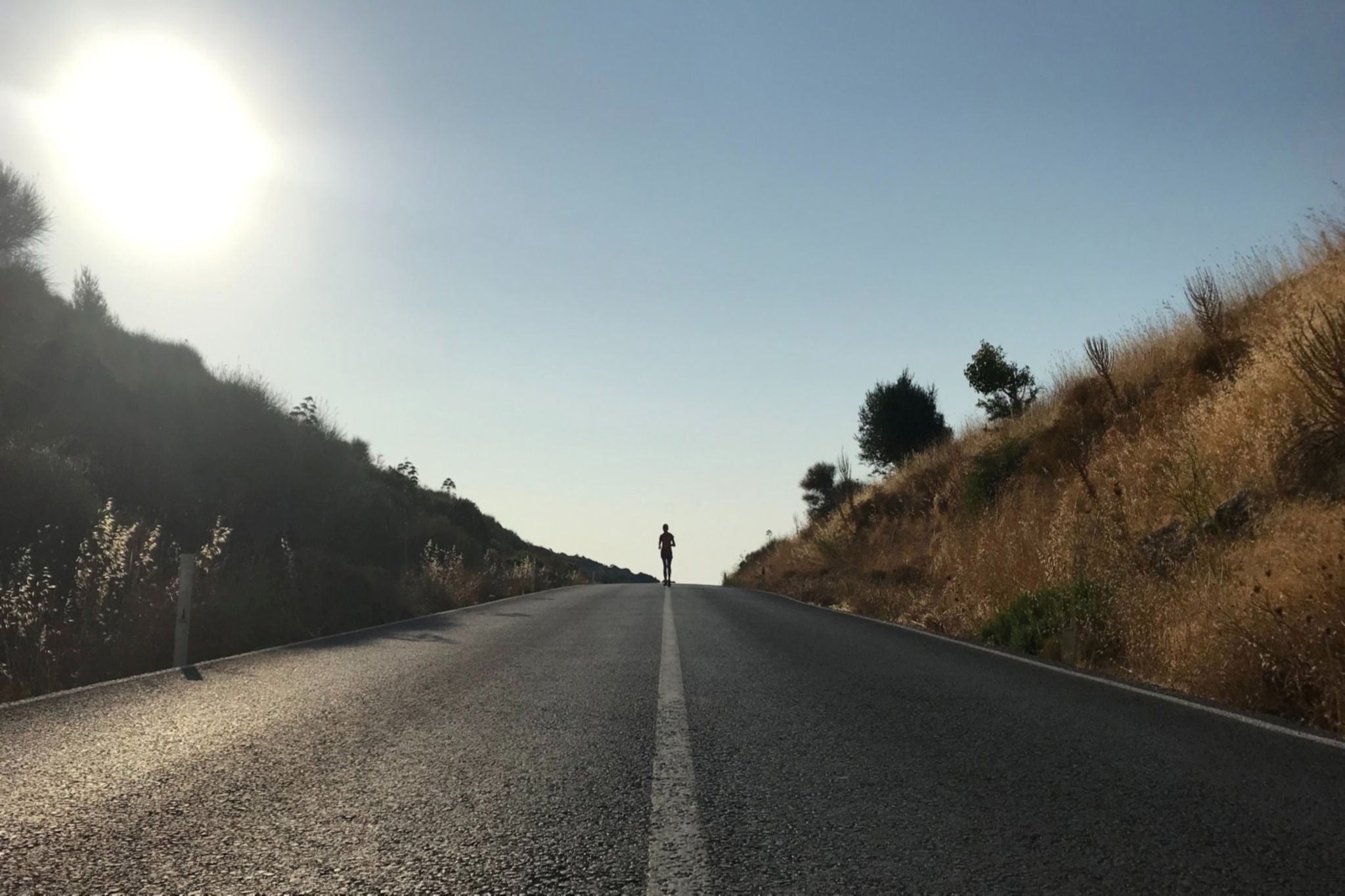 Woman running down road - Photo by Oktay Yildiz on Unsplash