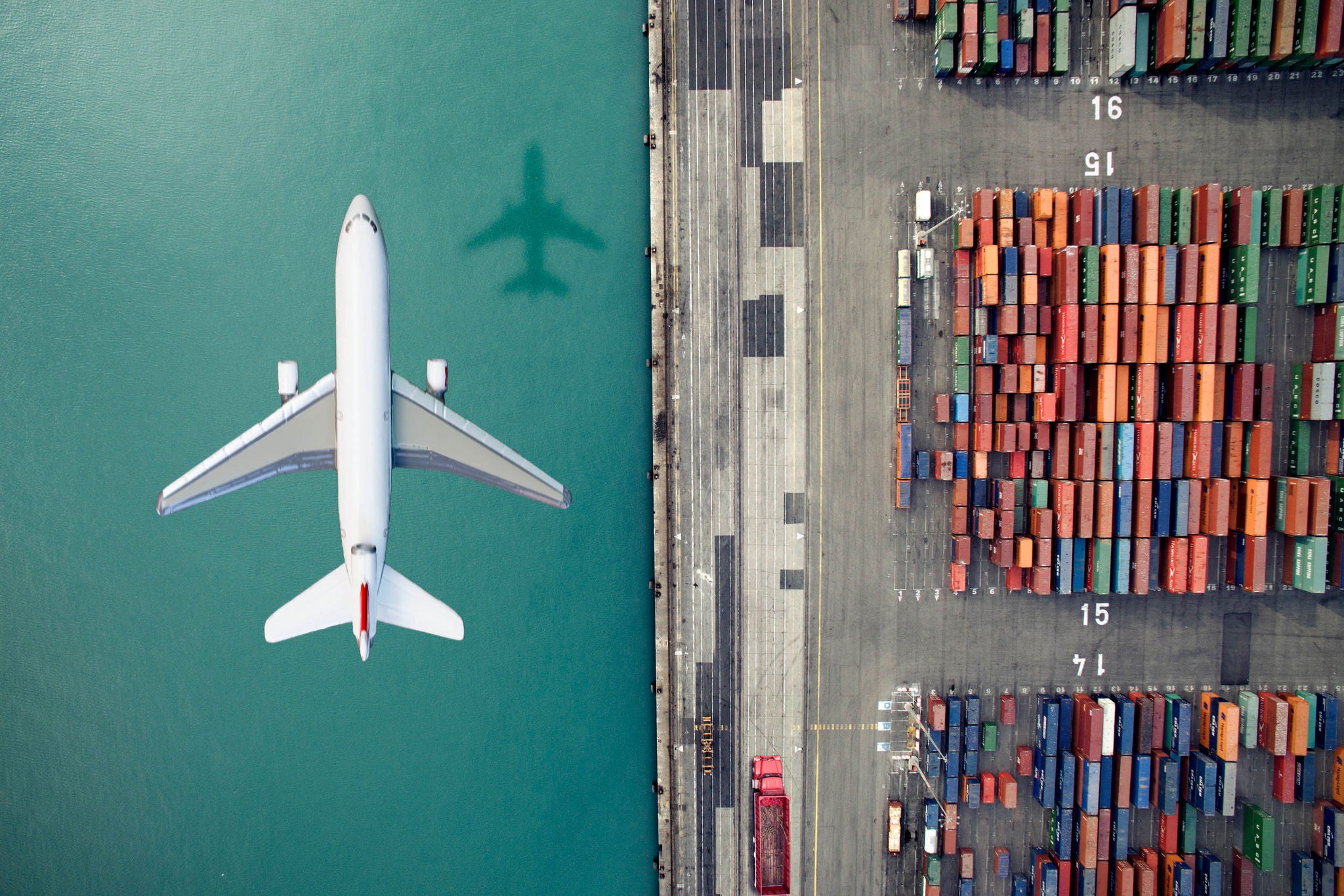 Airplane flying over ontainer port