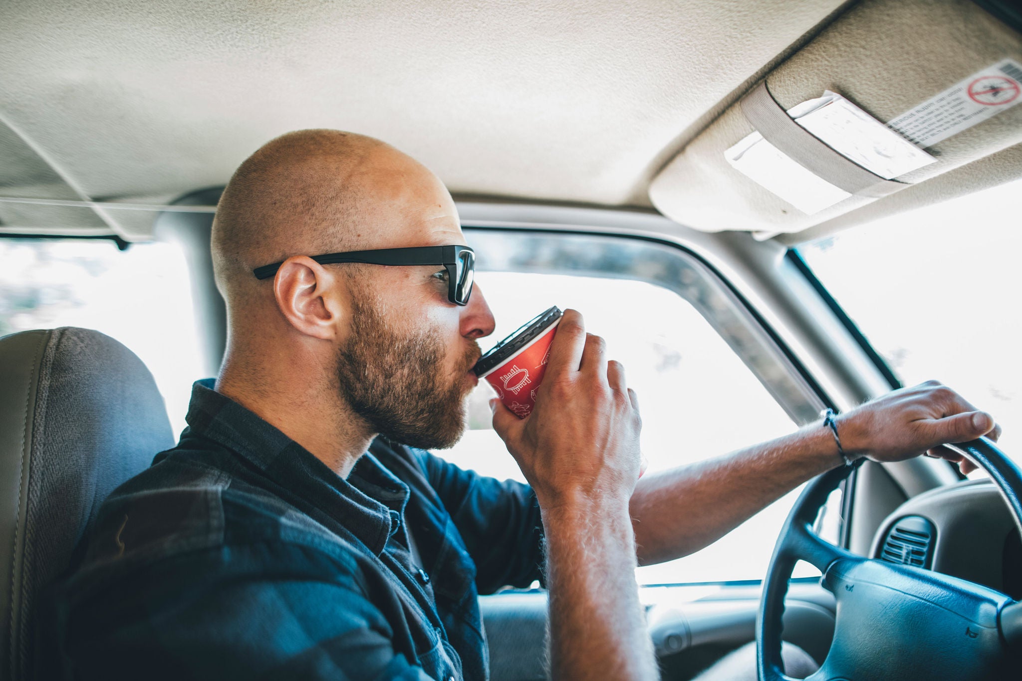 man sunglasses road trip takeaway drink