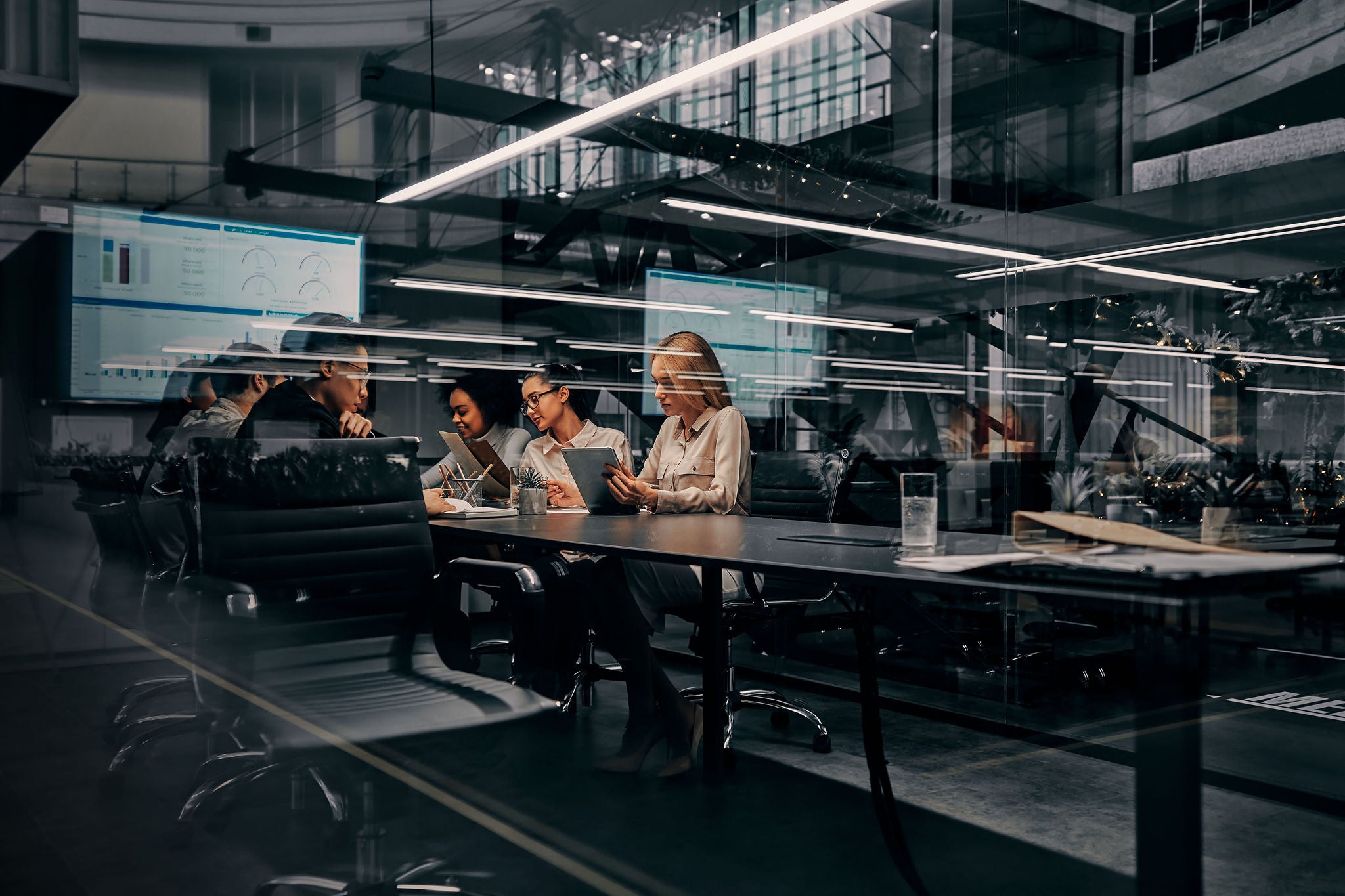 ey business women and men working in a conference room working on a project presentation