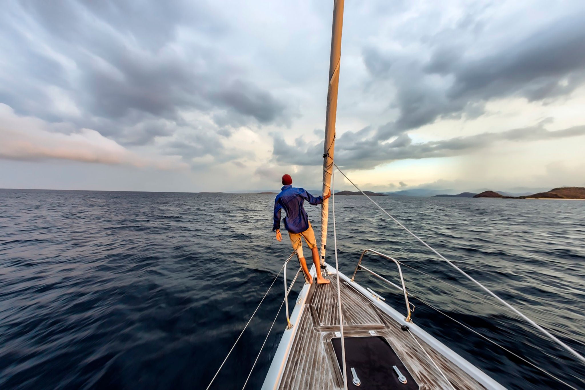 Man standing on a yatch in the middle of the ocean