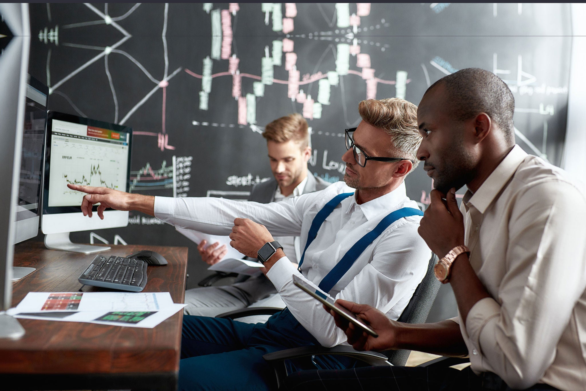 ey-three-colleagues-sitting-by-desks