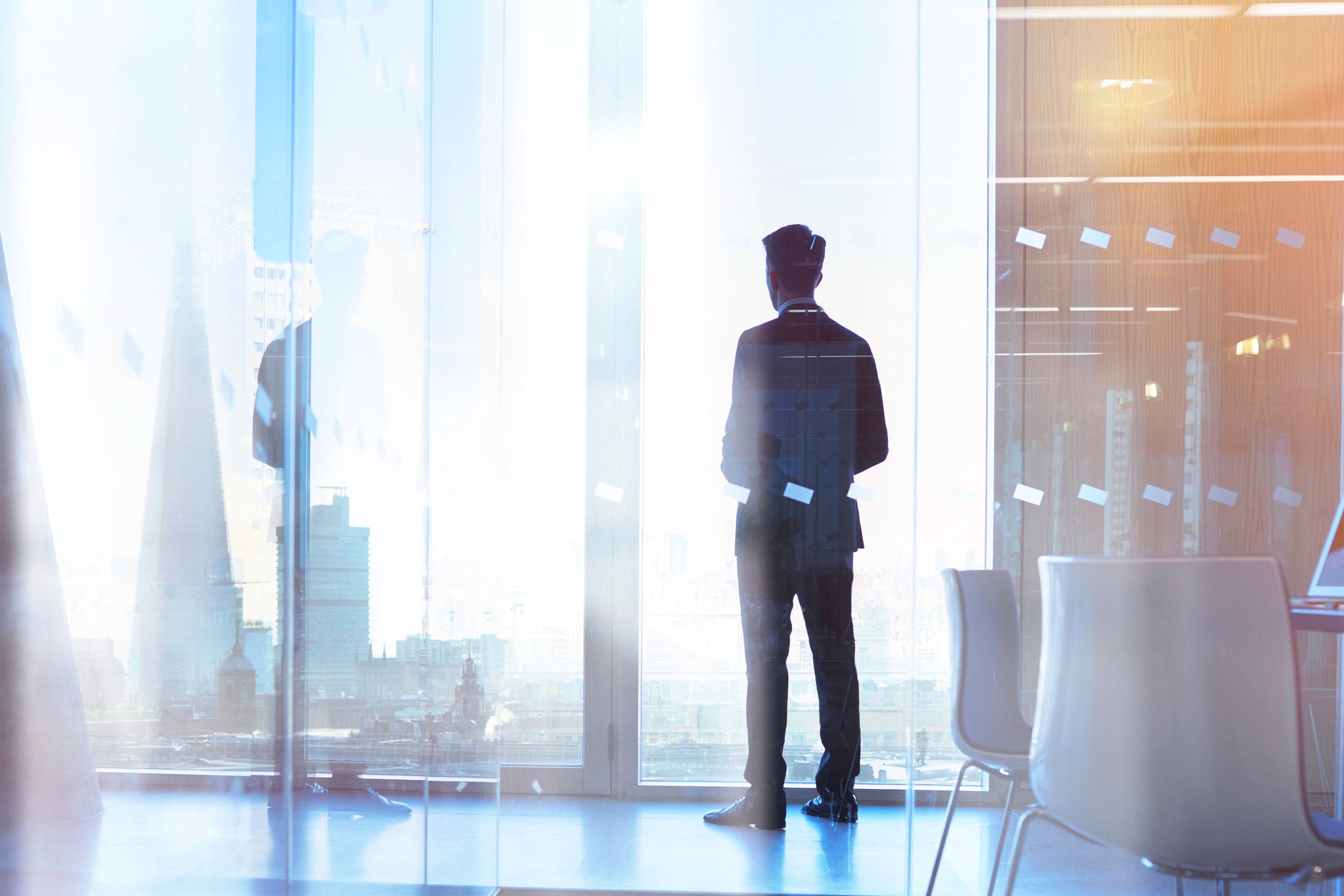 Businessman looking out of office over city