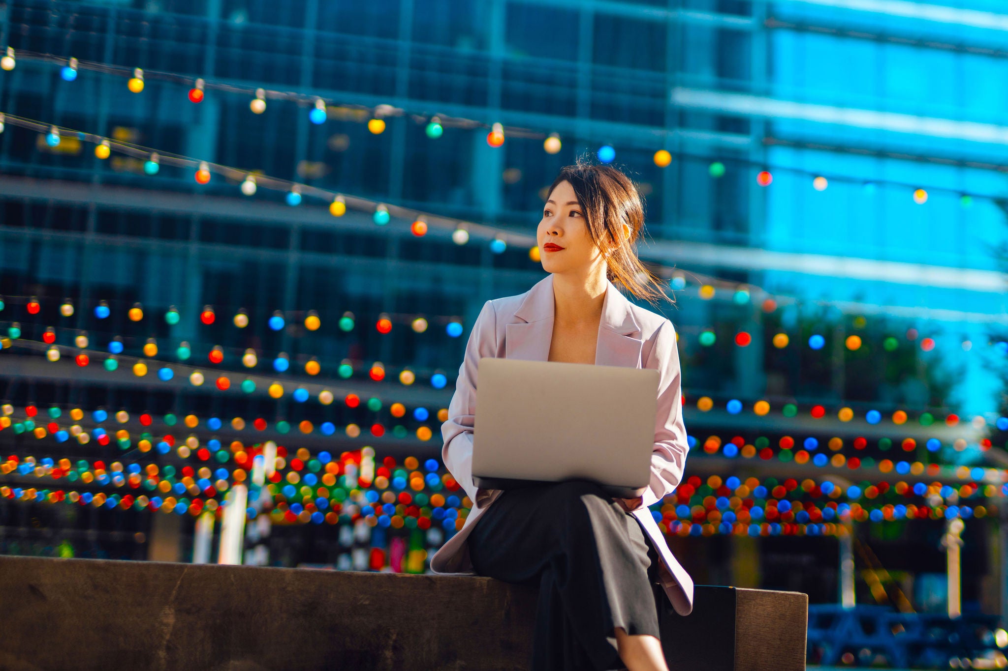 Portrait of Asian business woman in financial district with laptop. Young entrepreneur. Employment opportunity.