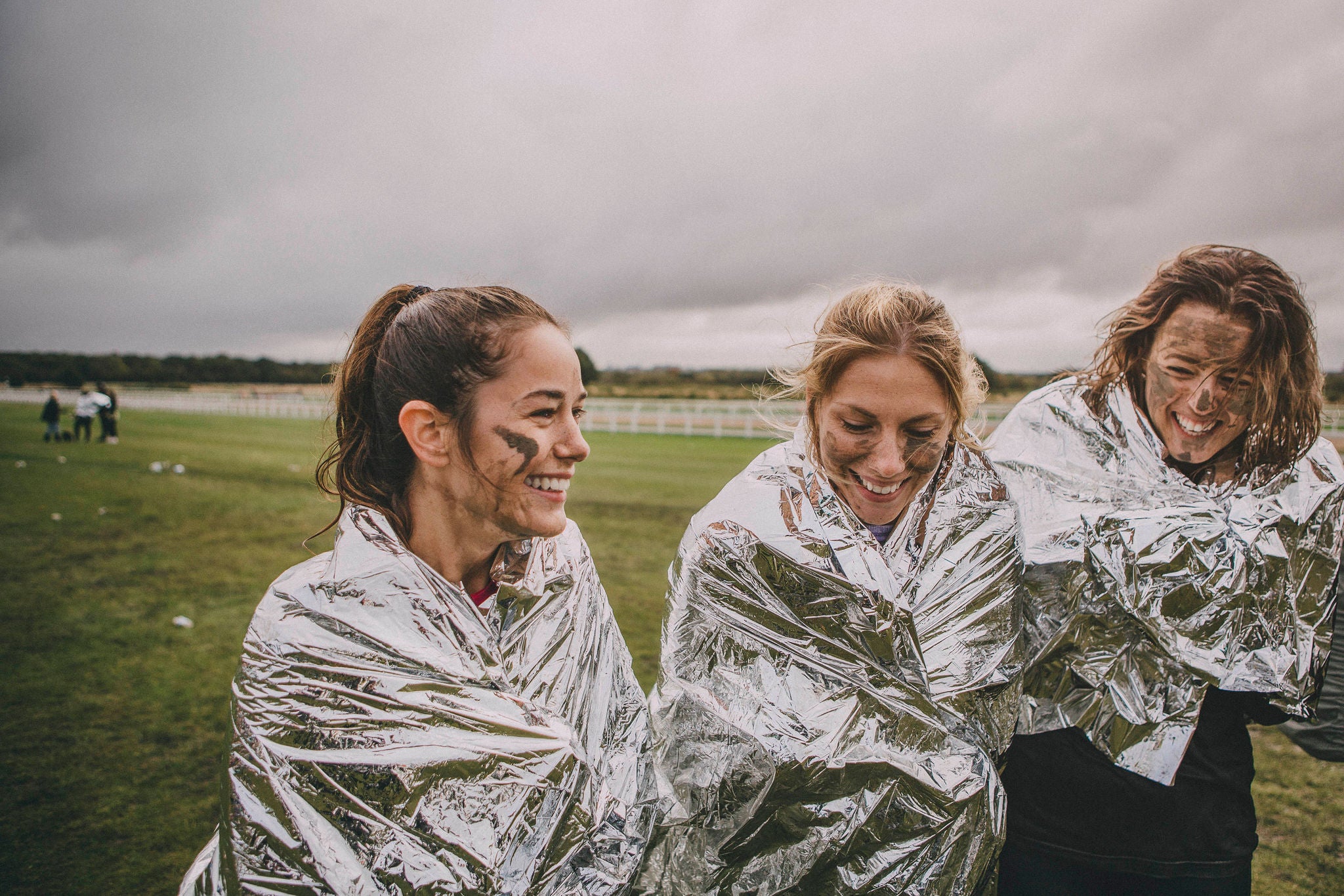 Group of friends are keeping warm with thermal foil blankets after completing a charity race.