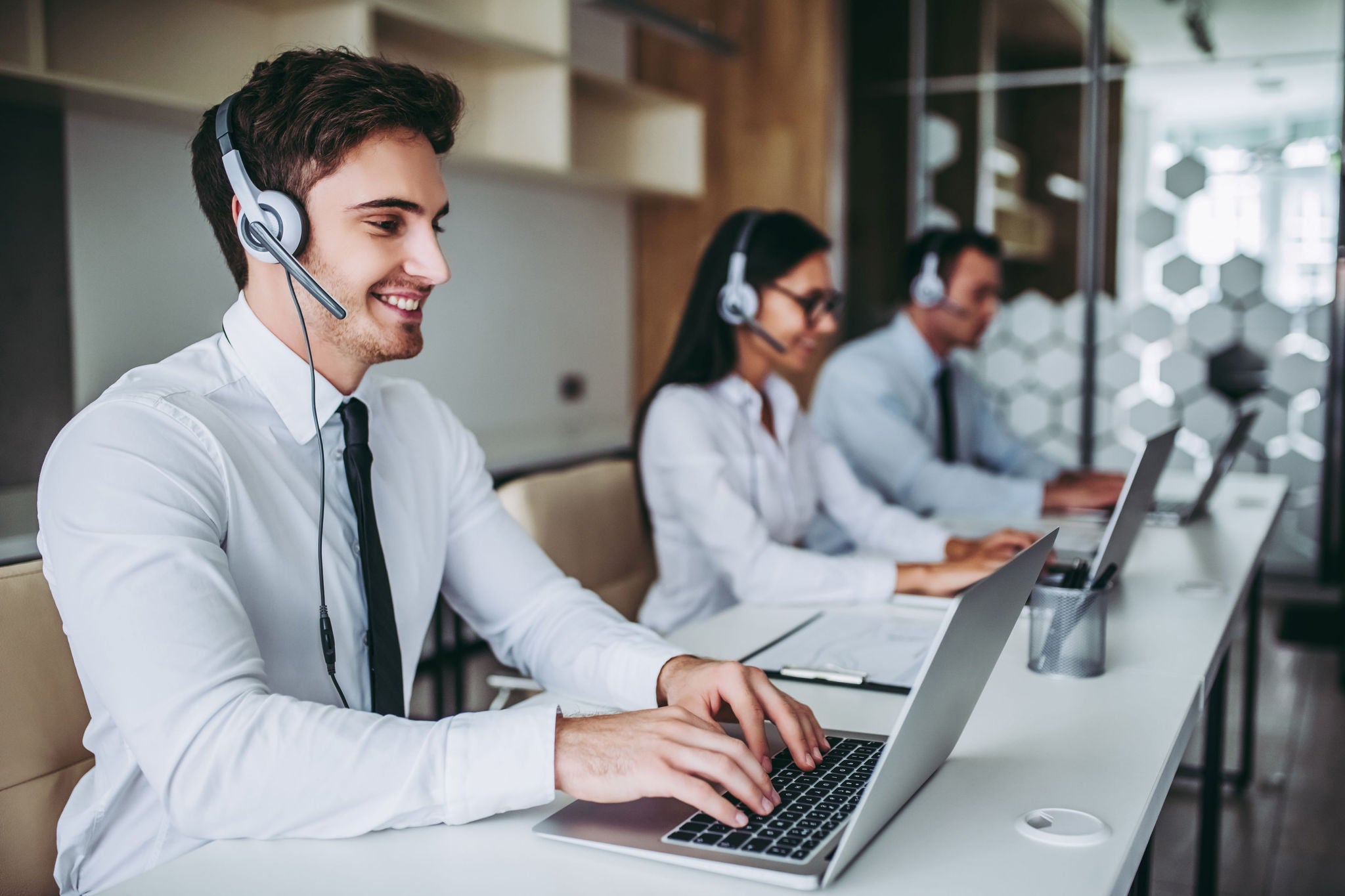 People working infornt of computer using headphone