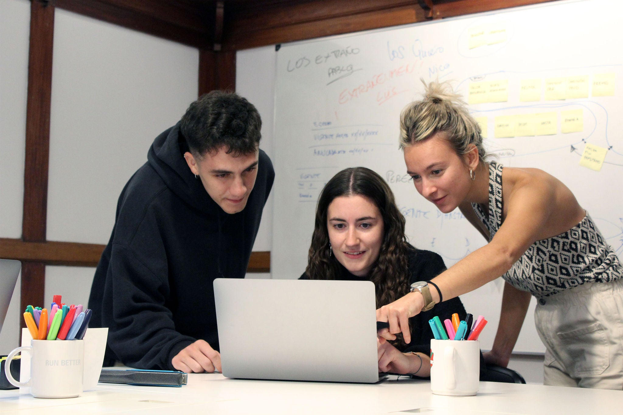 Tres personas mirando la pantalla del ordenador portátil