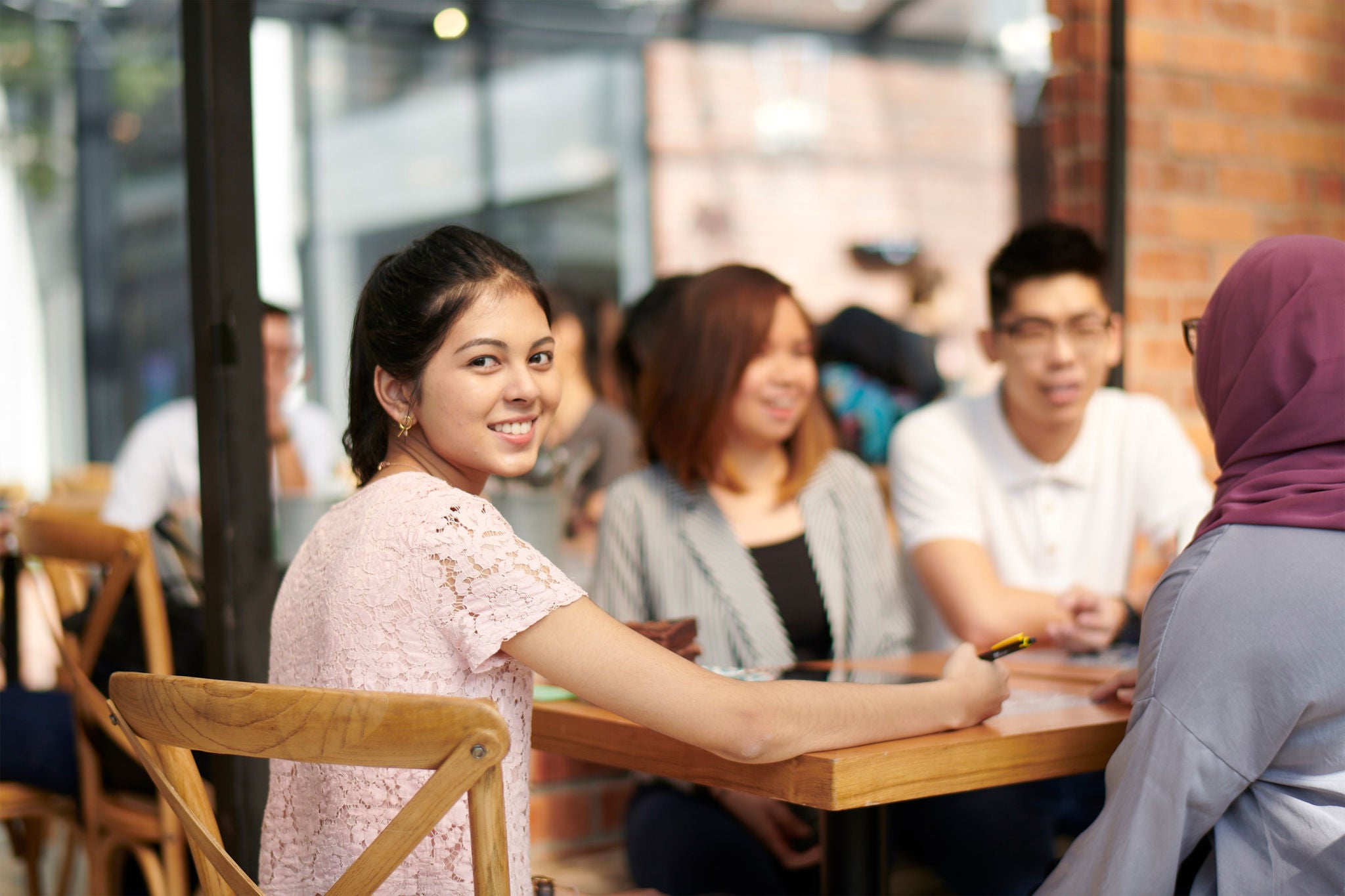 Girl sitting on a chair with friends and smiling