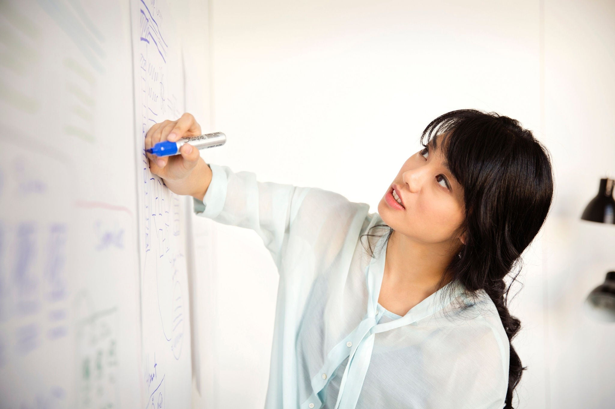 woman writing private equity related topics on a white board