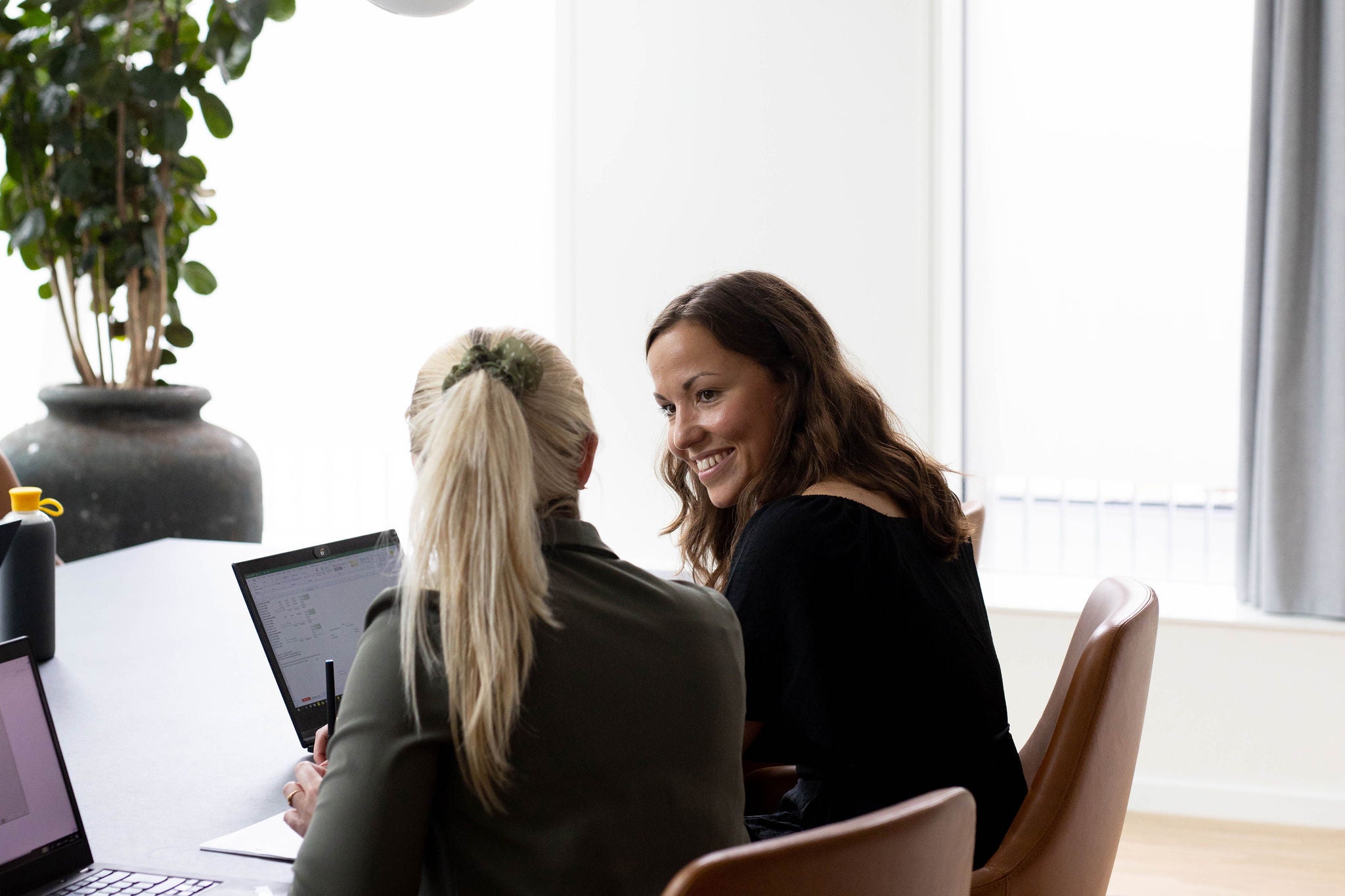 two woman sitting side by side and discussing about work