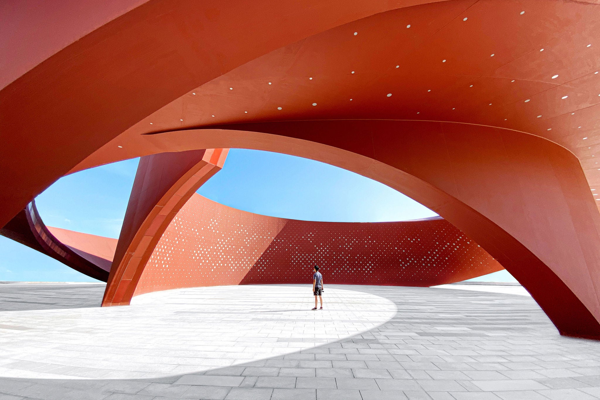Person in a red curved abstract architectural space