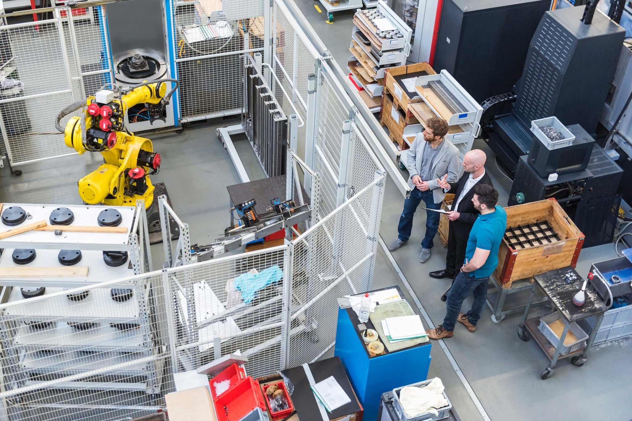 Businessman and employees discussing in modern factory