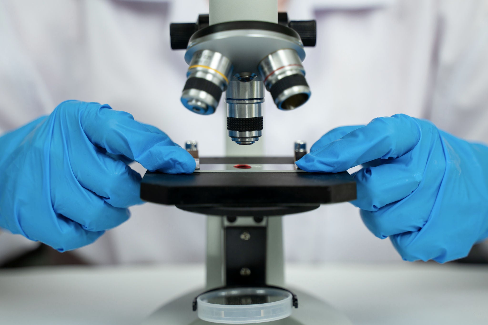 Scientist researcher using microscope in laboratory. Medical healthcare technology and pharmaceutical research and development concept.