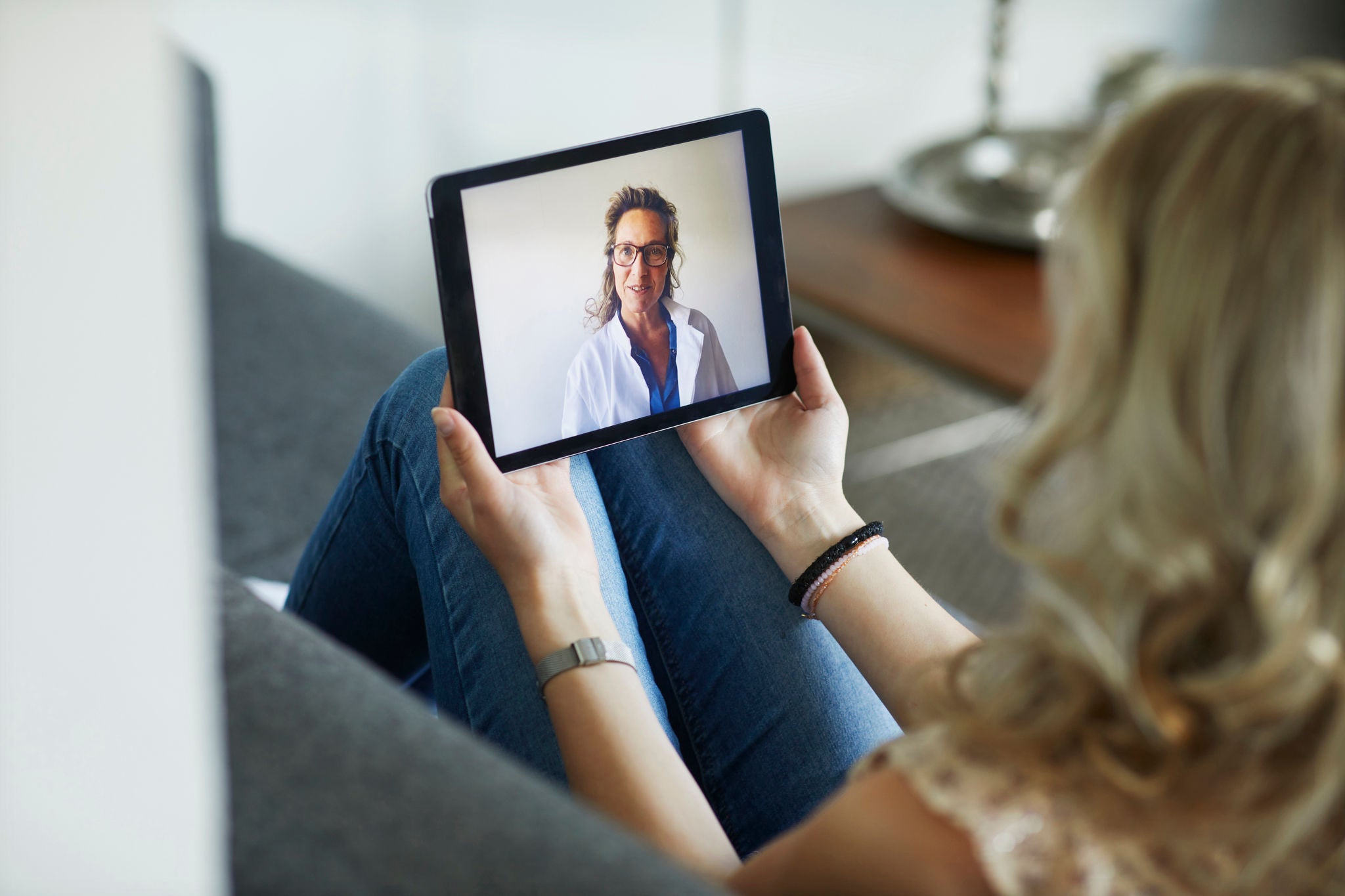 Young woman having online meeting with female healthcare person