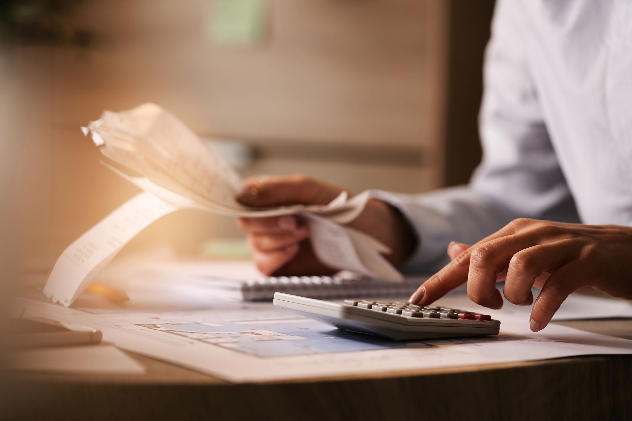 Close-up of business accountant using calculator while working in the office.