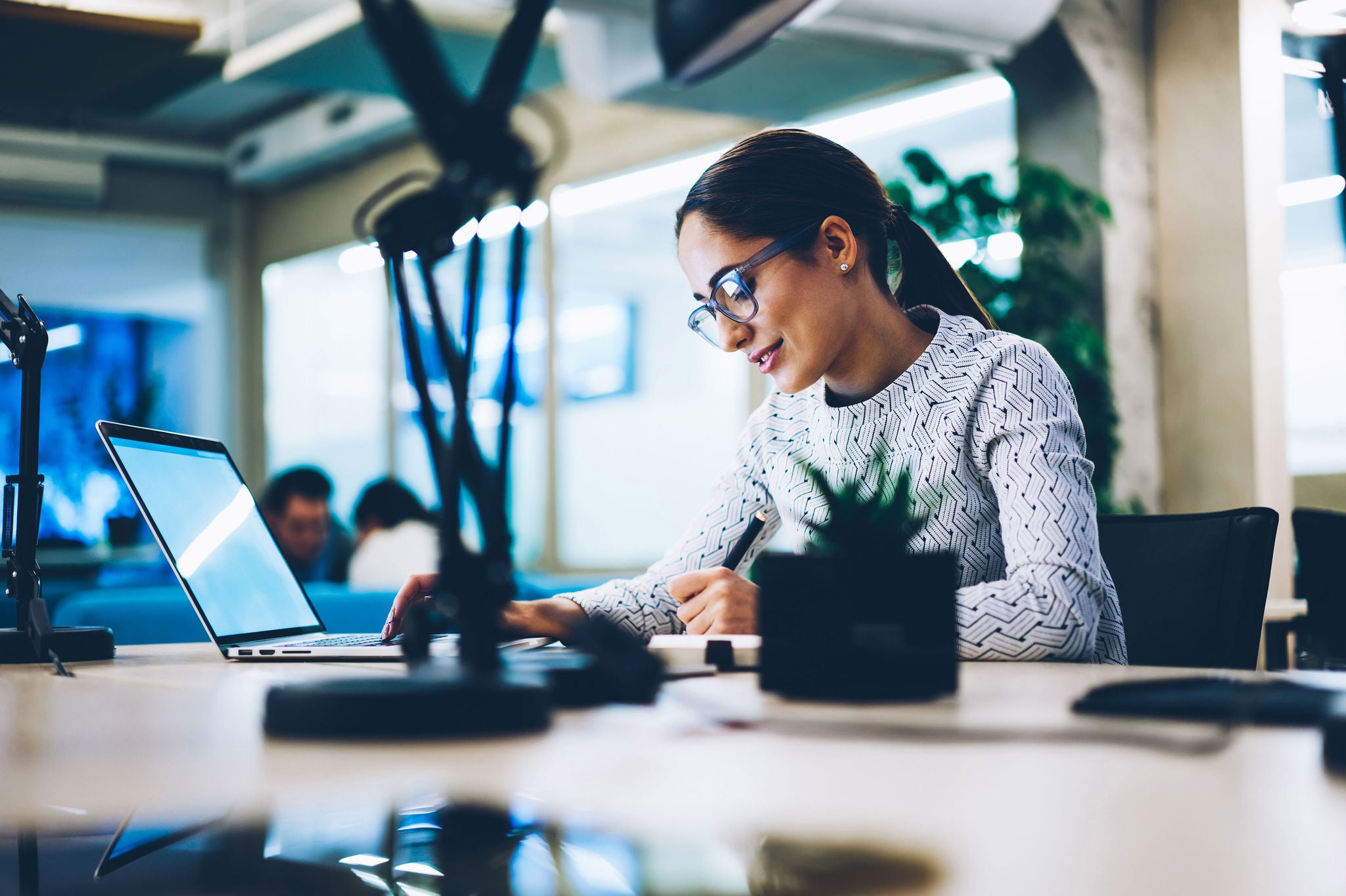 ey-professional-female-using-laptop-and-writing-on-notepad