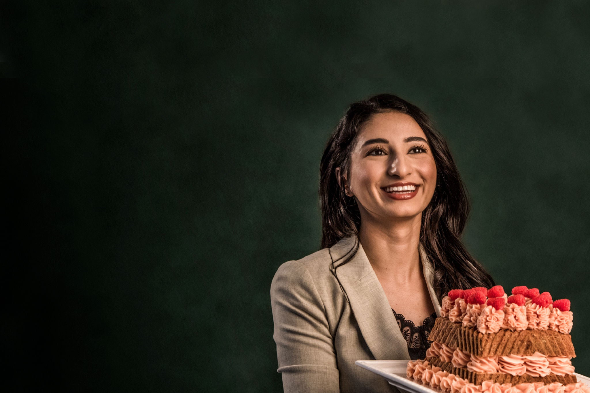 A lady is holding a cake.