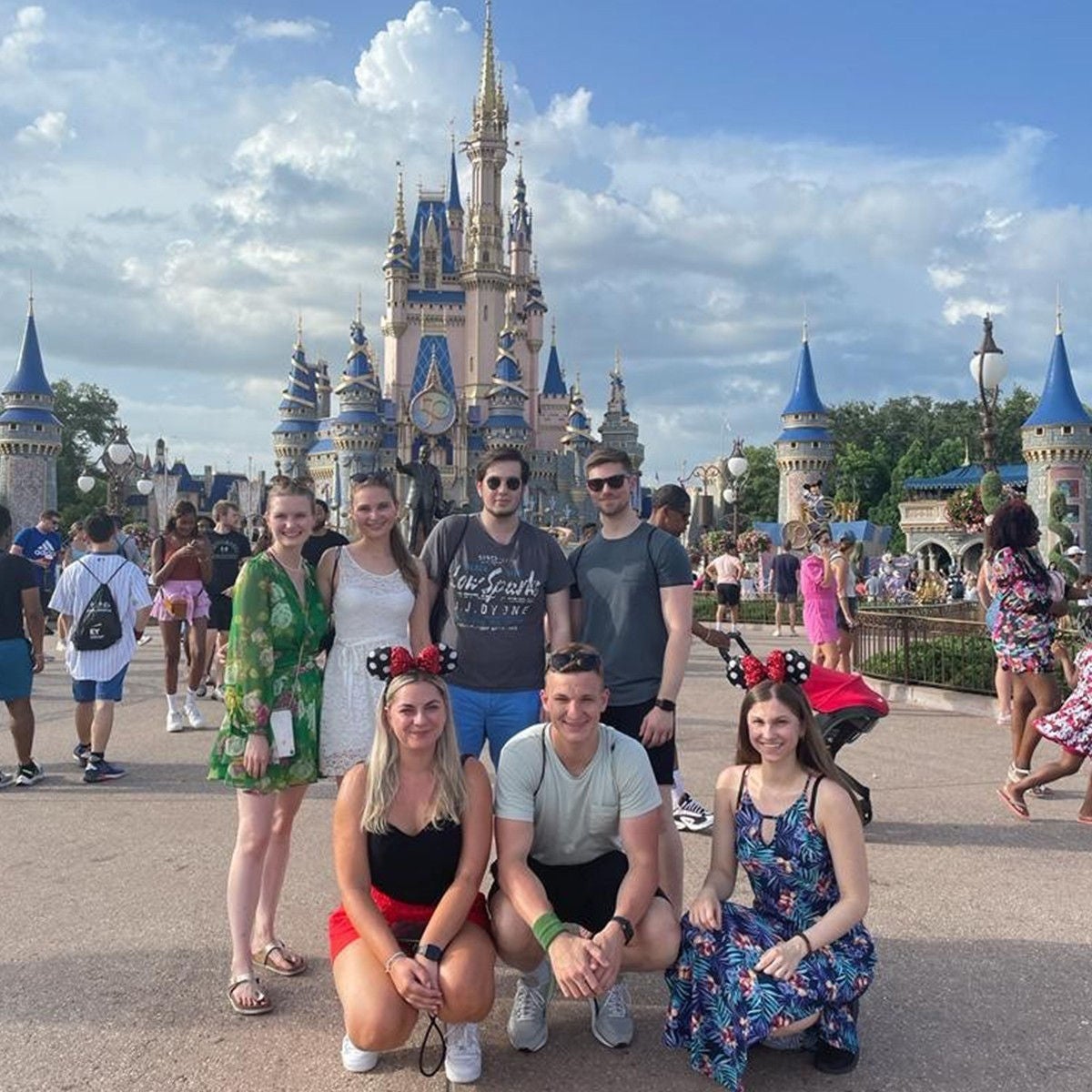 Photo of seven friends posing for the camera infront of the walt disney world