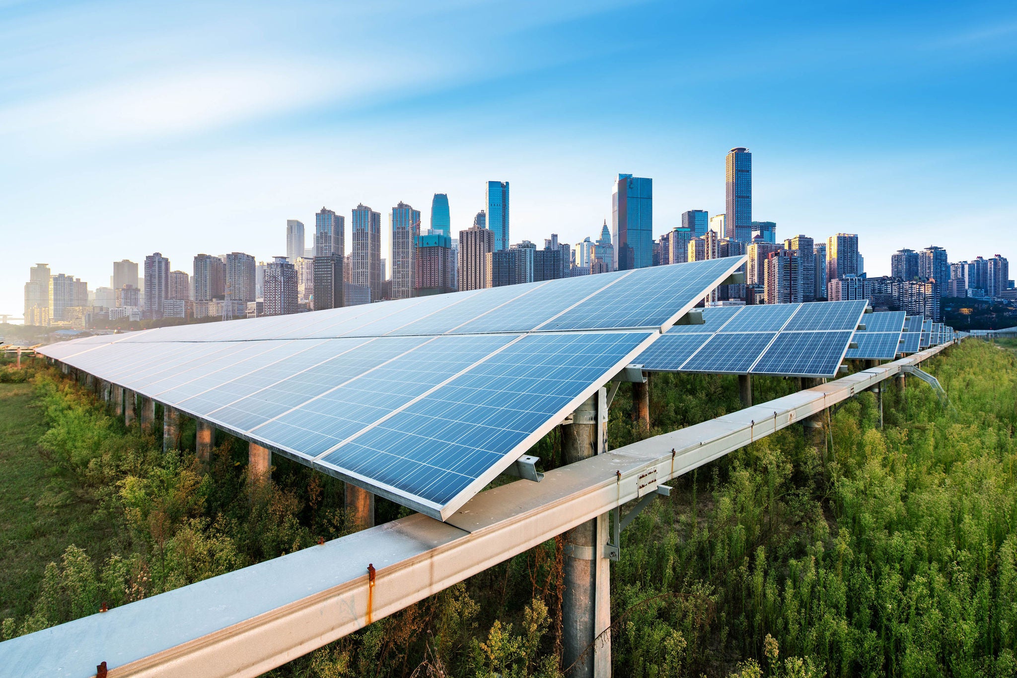  Cellules photovoltaïques capturant la lumière du soleil avec en arrière-plan la ligne d'horizon de la ville de Chongqing en Chine.