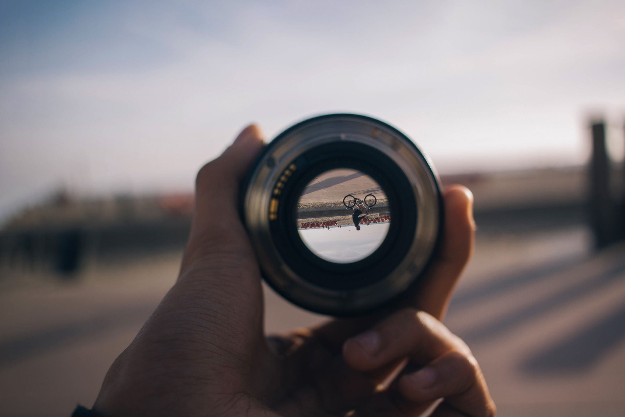 Person holding camera lens