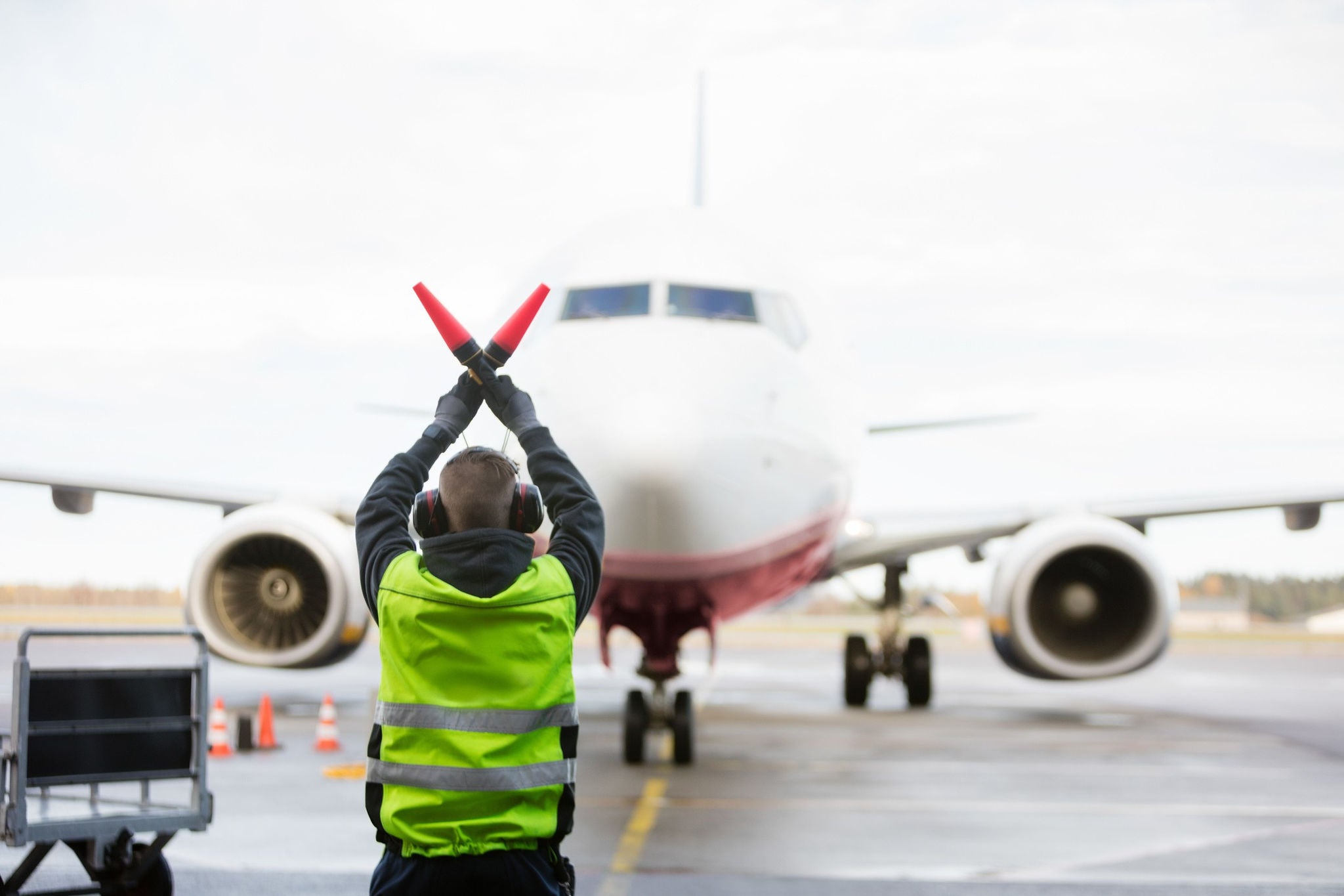 Ground worker signalling the Aeroplane on runway