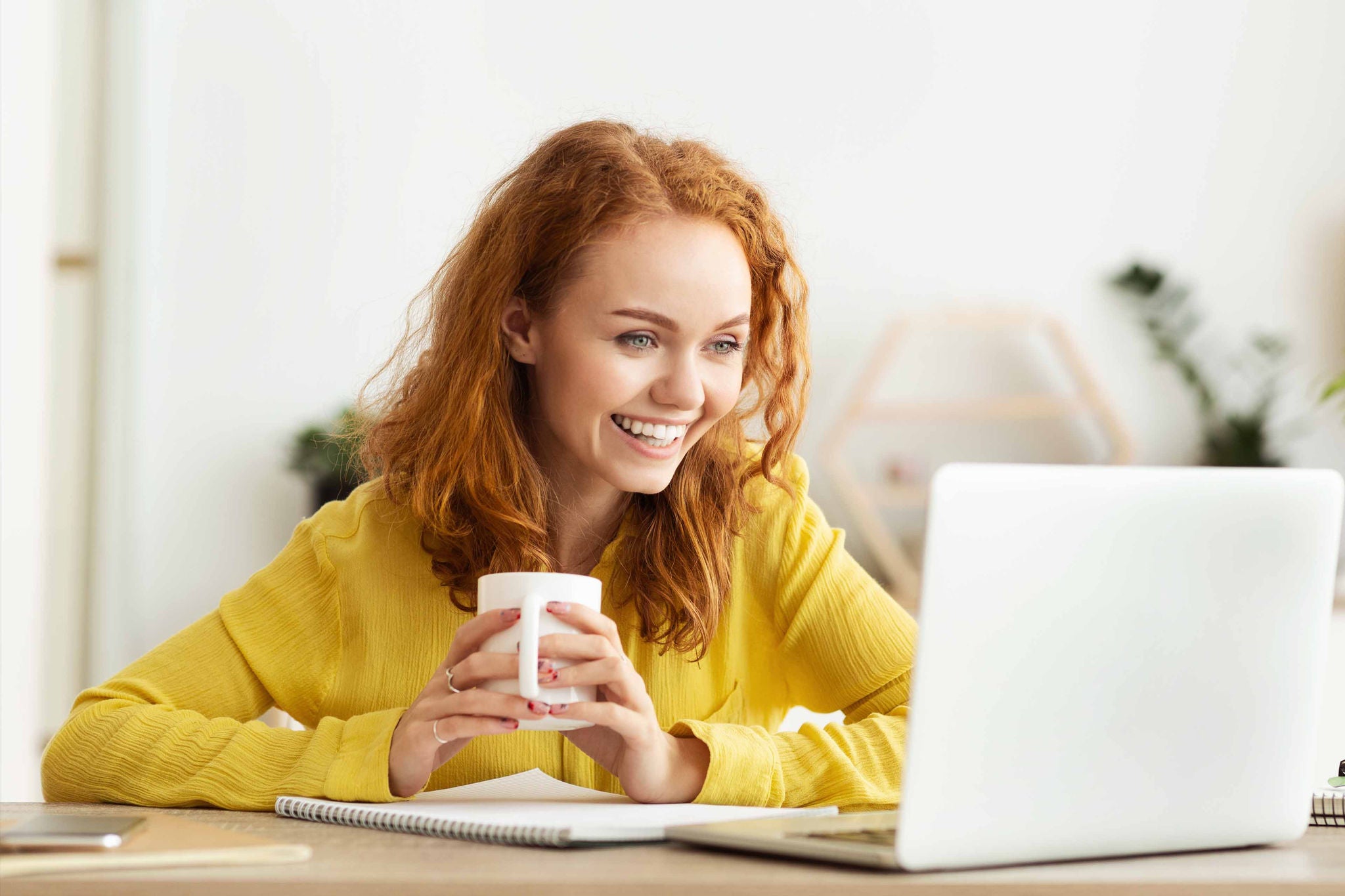 Women looking at the laptop while having coffee