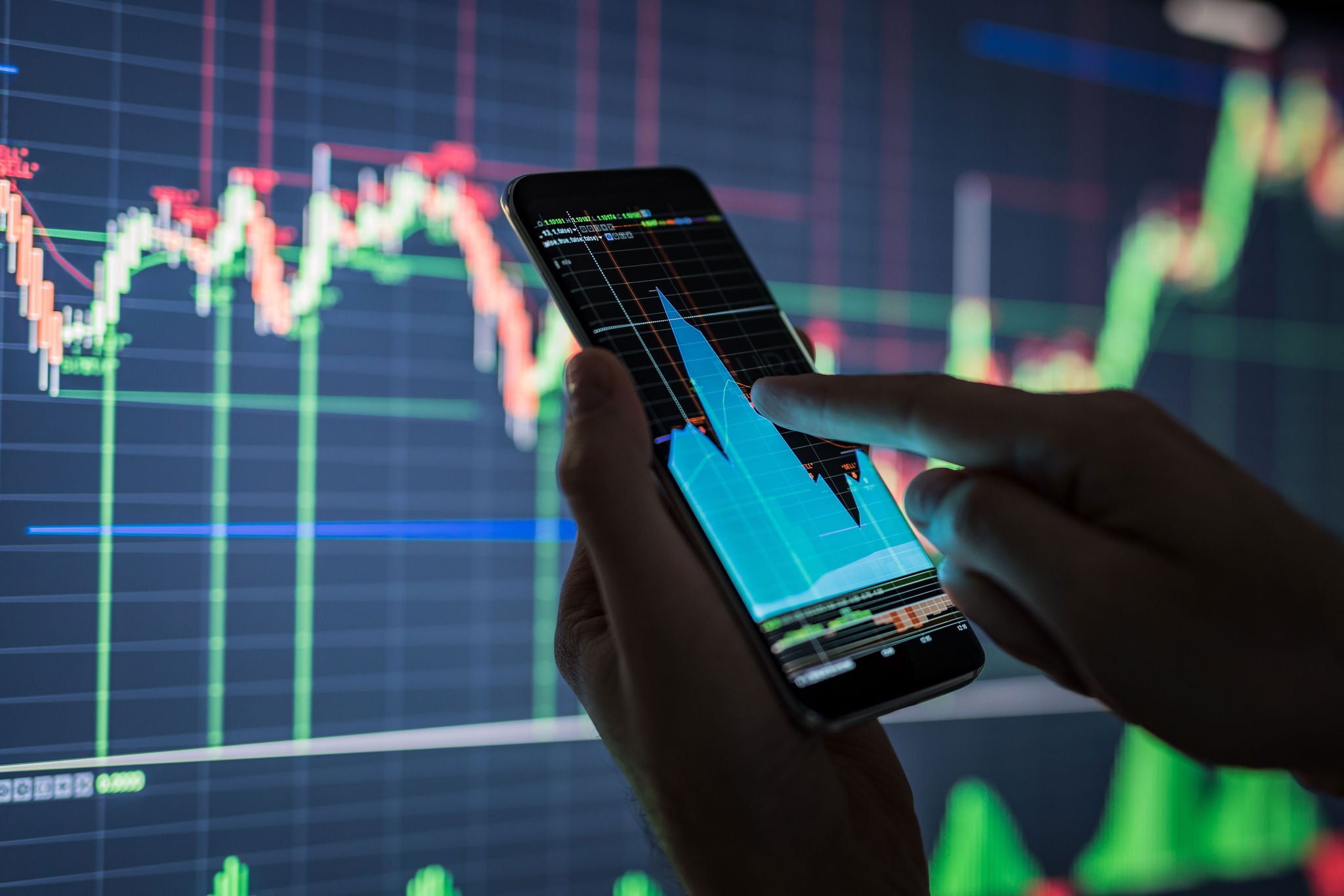 Businessman checking stock market data on a mobile phone.