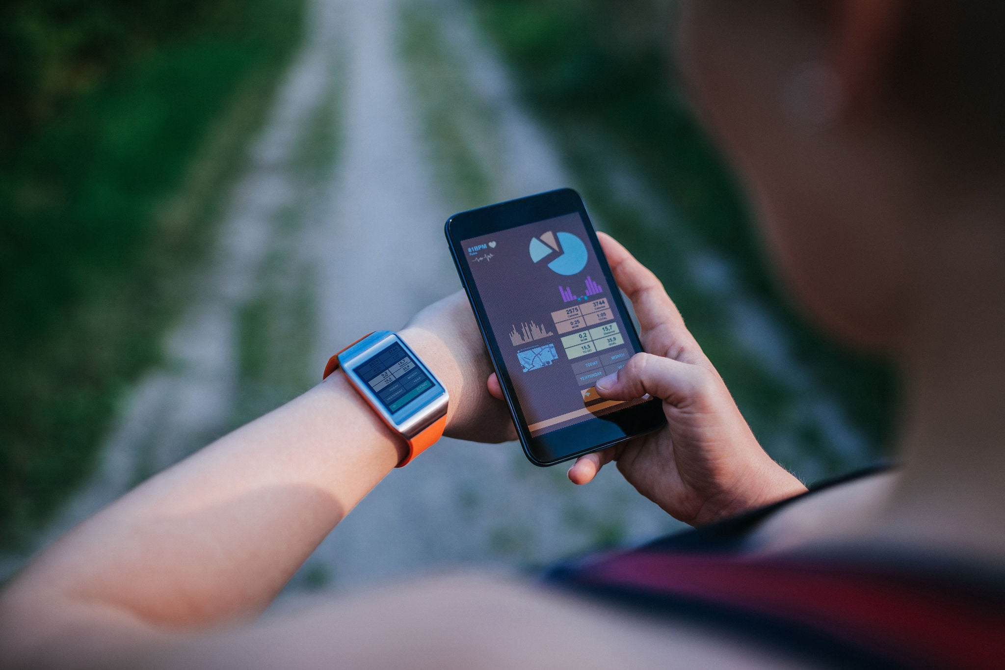 Woman synchronising smartwatch and mobile phone